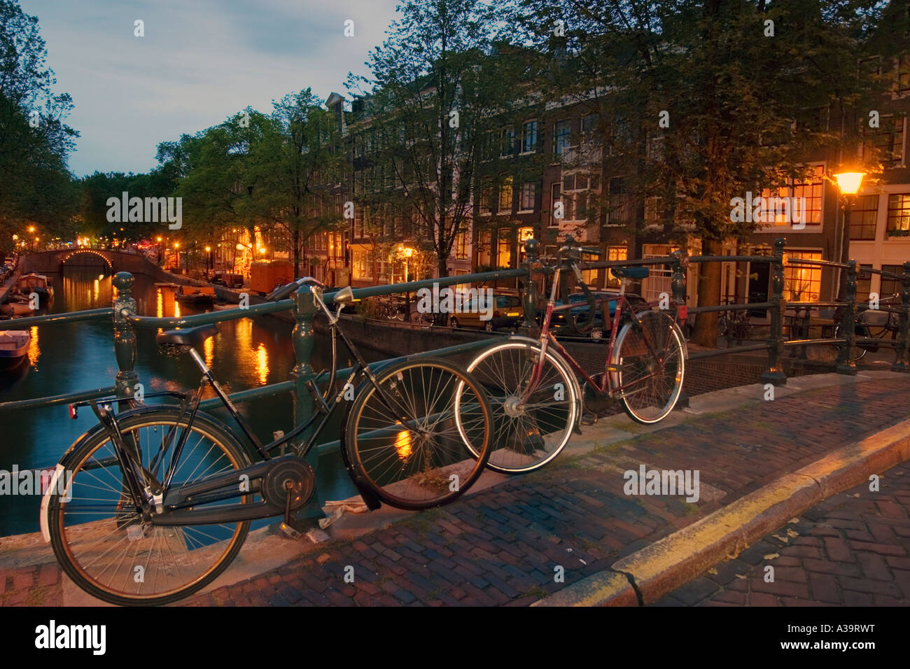 Amsterdam briudge over canal at twilight bicycles Stock Photo