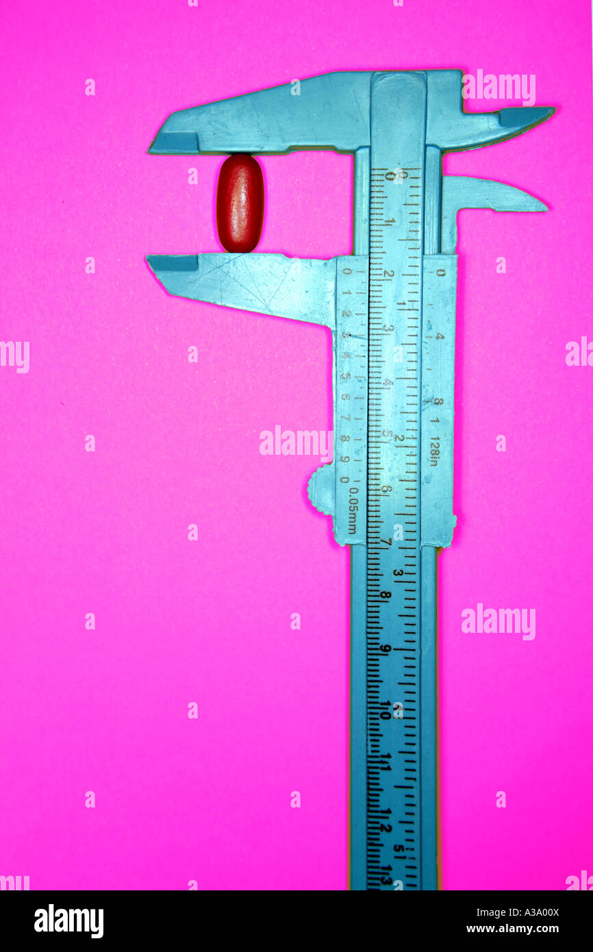 Pill in calipers Stock Photo Alamy