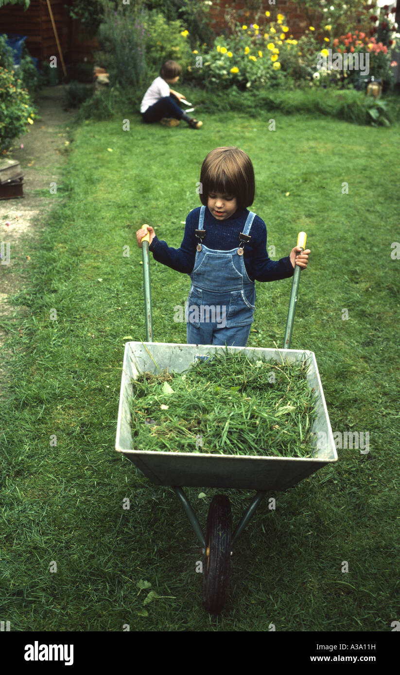 young girl with wheelbarrow full of grass Stock Photo - Alamy