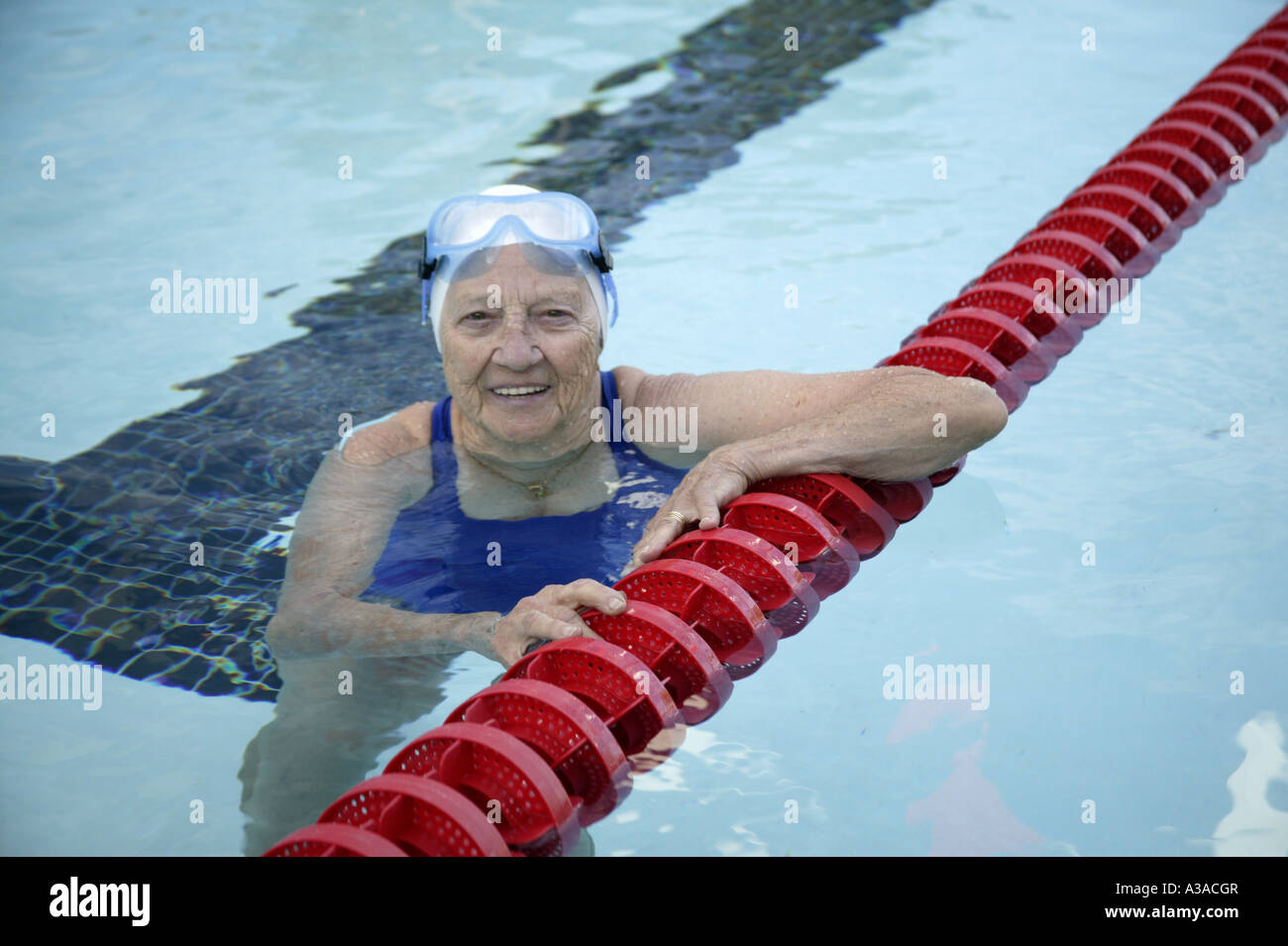 Senior woman preparing to swim laps, outdoor swimming pool Stock Photo