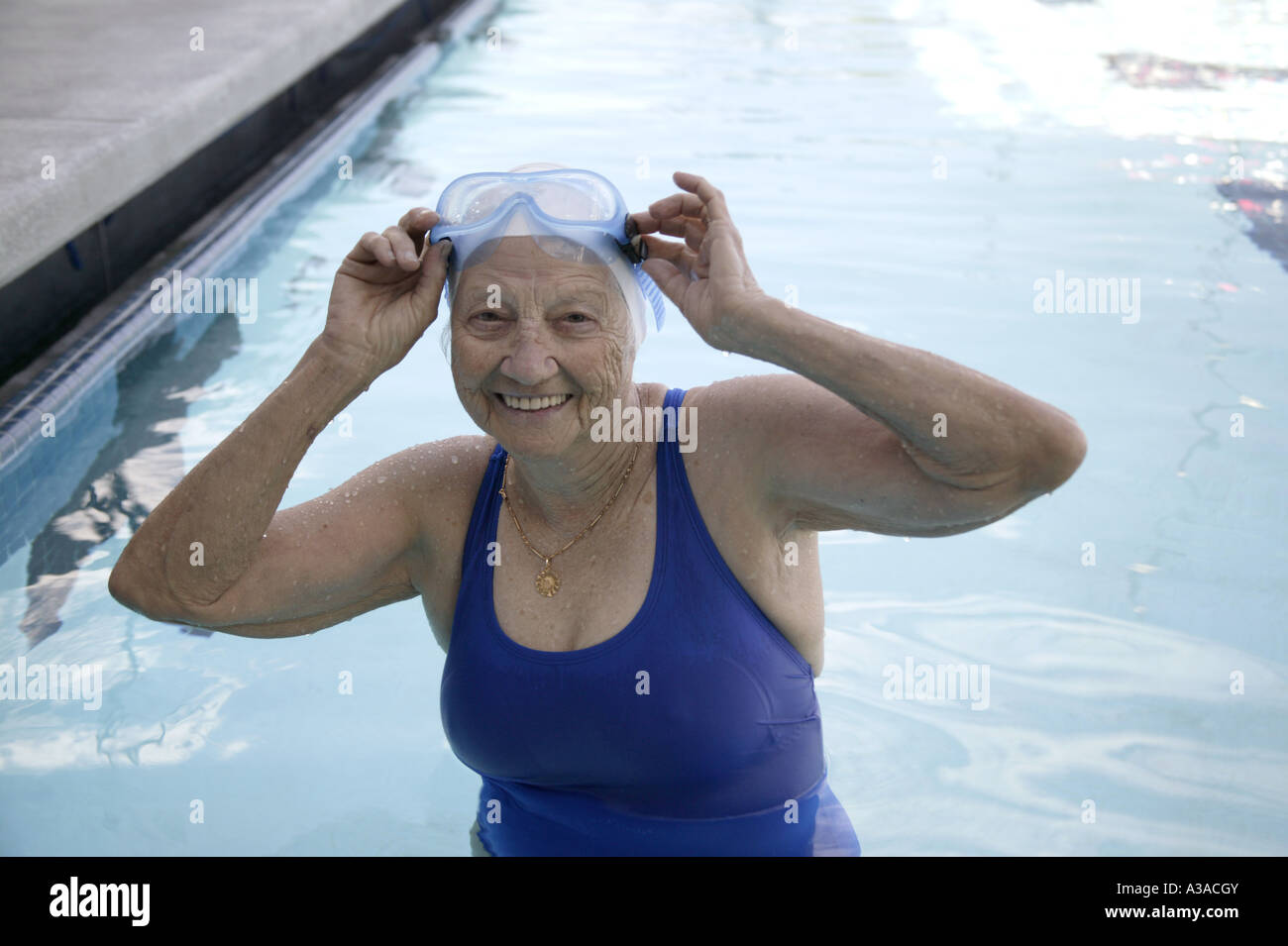 Sr. woman adjust goggles,  outdoor swimming pool. Stock Photo