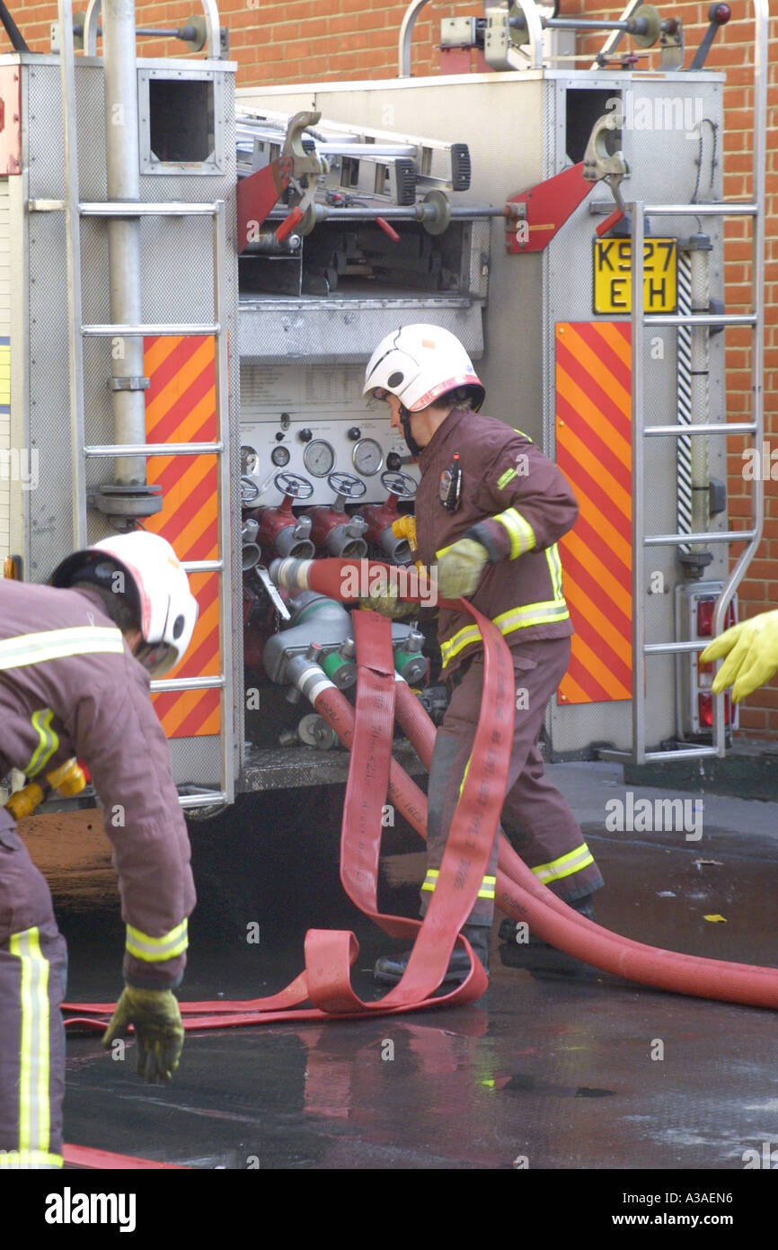 Fire fighters connecting hoses to the water mains Stock Photo
