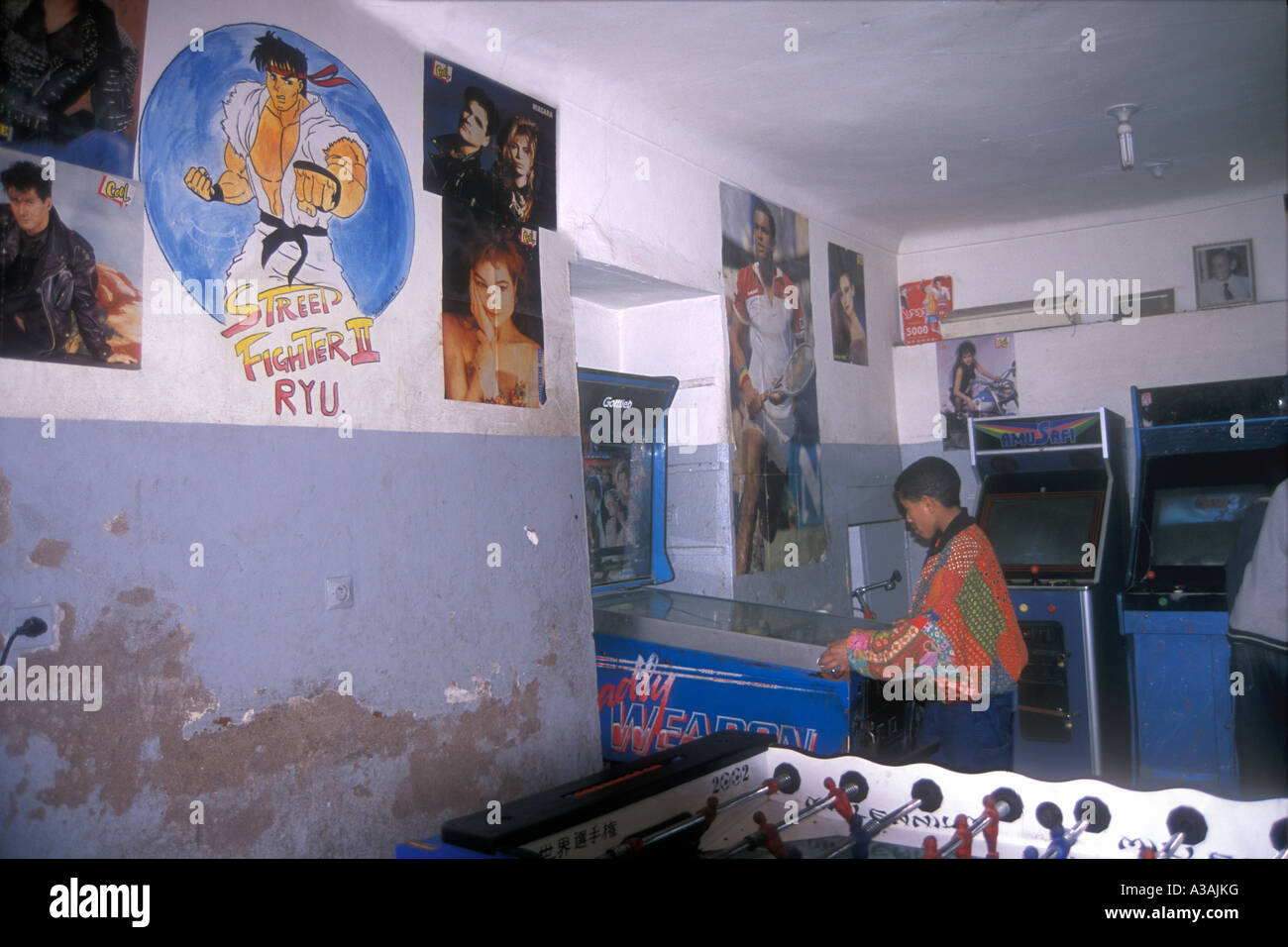 Moroccan youth playing on a pinball in a gaming arcade Place Djemaa el Fna Marrakesh Morocco