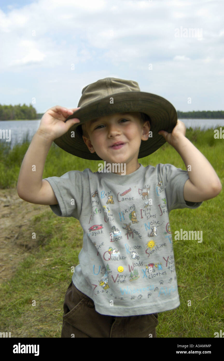 https://c8.alamy.com/comp/A3AMMP/p20-137-4-year-old-boy-wears-fathers-fishing-hat-by-lake-A3AMMP.jpg