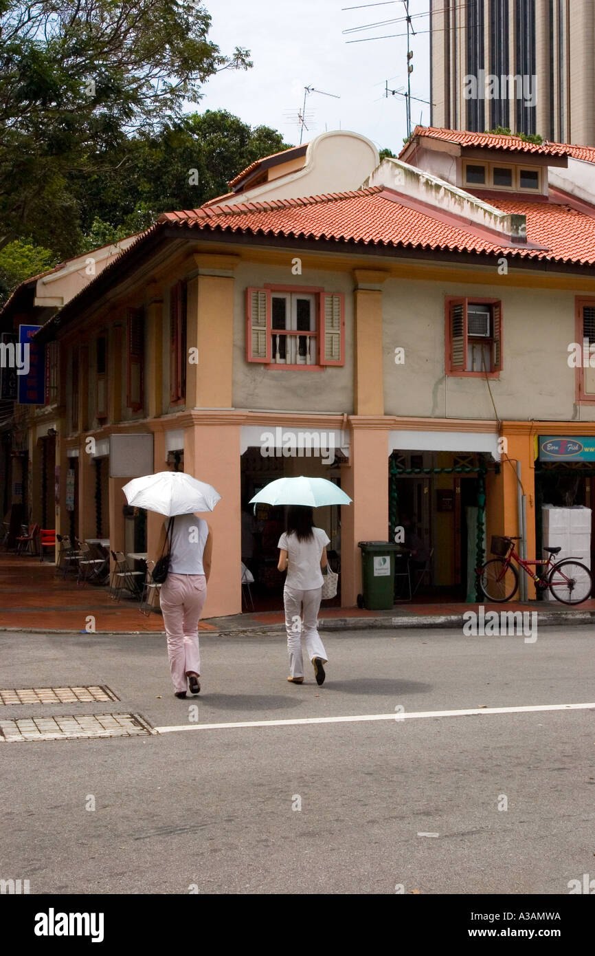 Pedestrians crossing road shelter from strong sun with umbrellas Stock ...