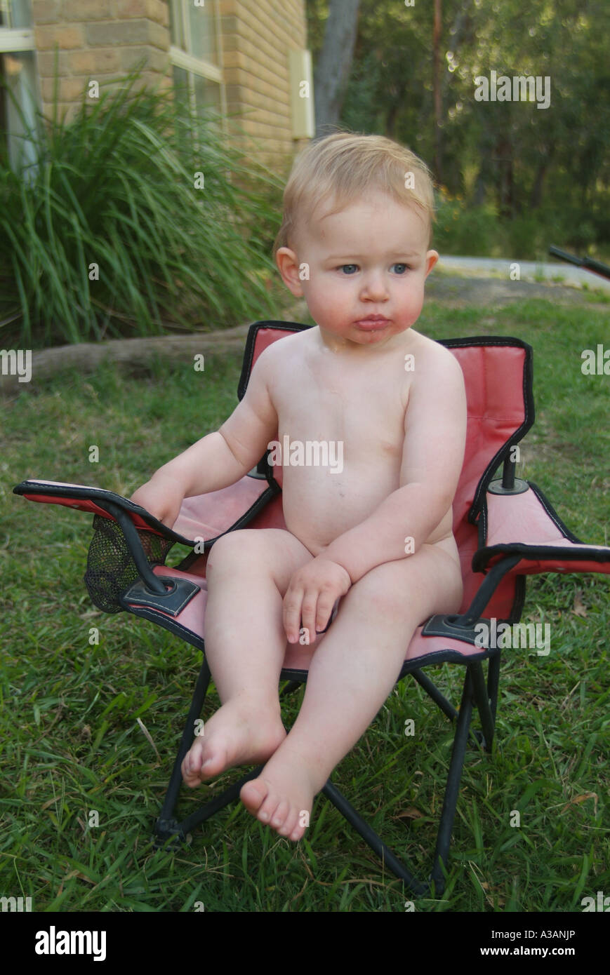 young boy sitting on a chair in summer without clothes on Stock Photo -  Alamy