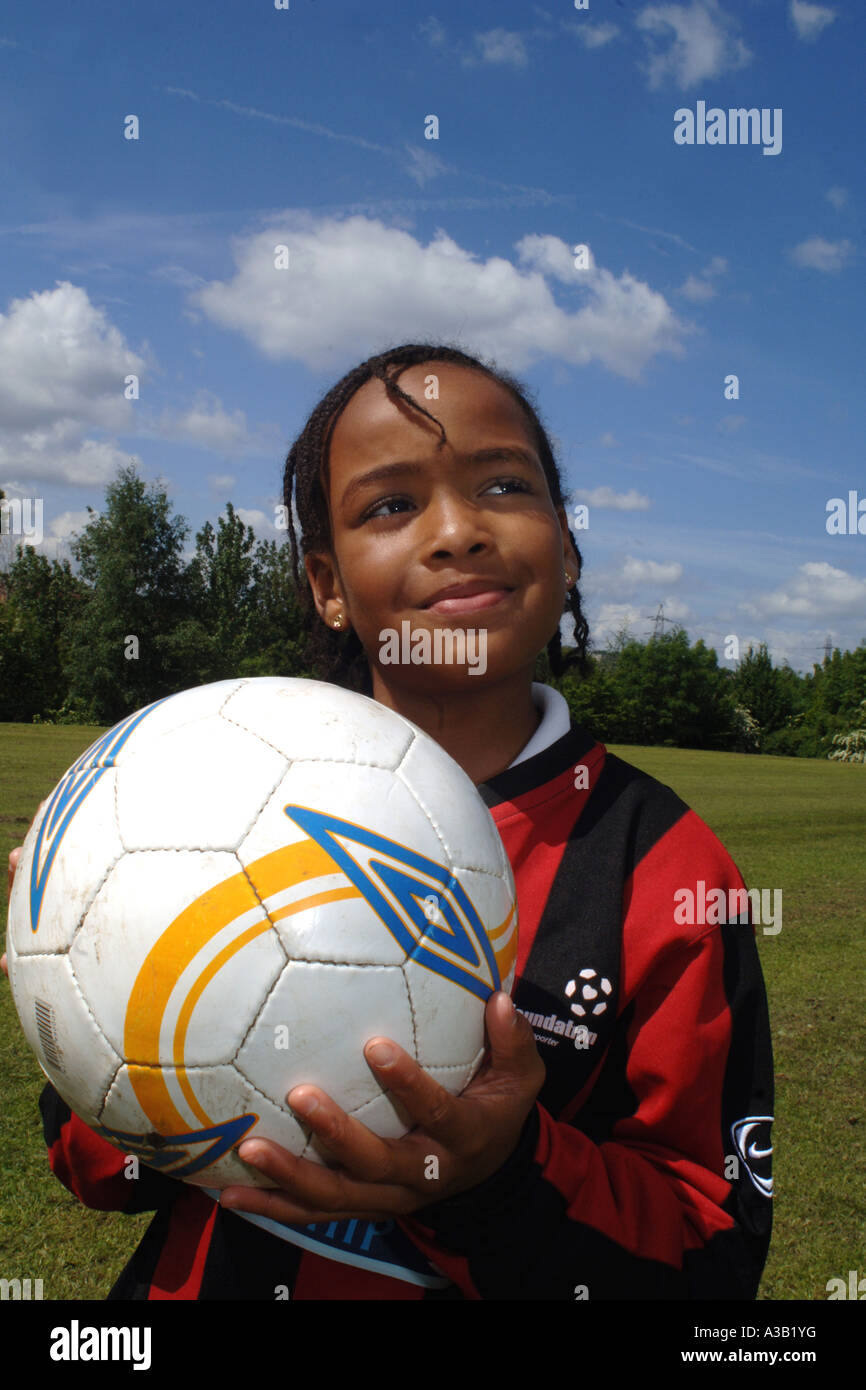 Girl holds a football on the school playing field West Yorkshire Stock Photo