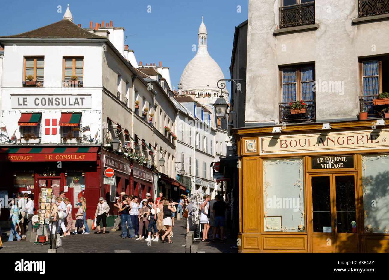 FRANCE Ile de France Paris Montmartre Tourists in narrow streets between boulangerie and Consulat Restaurant near Sacre Couer Stock Photo