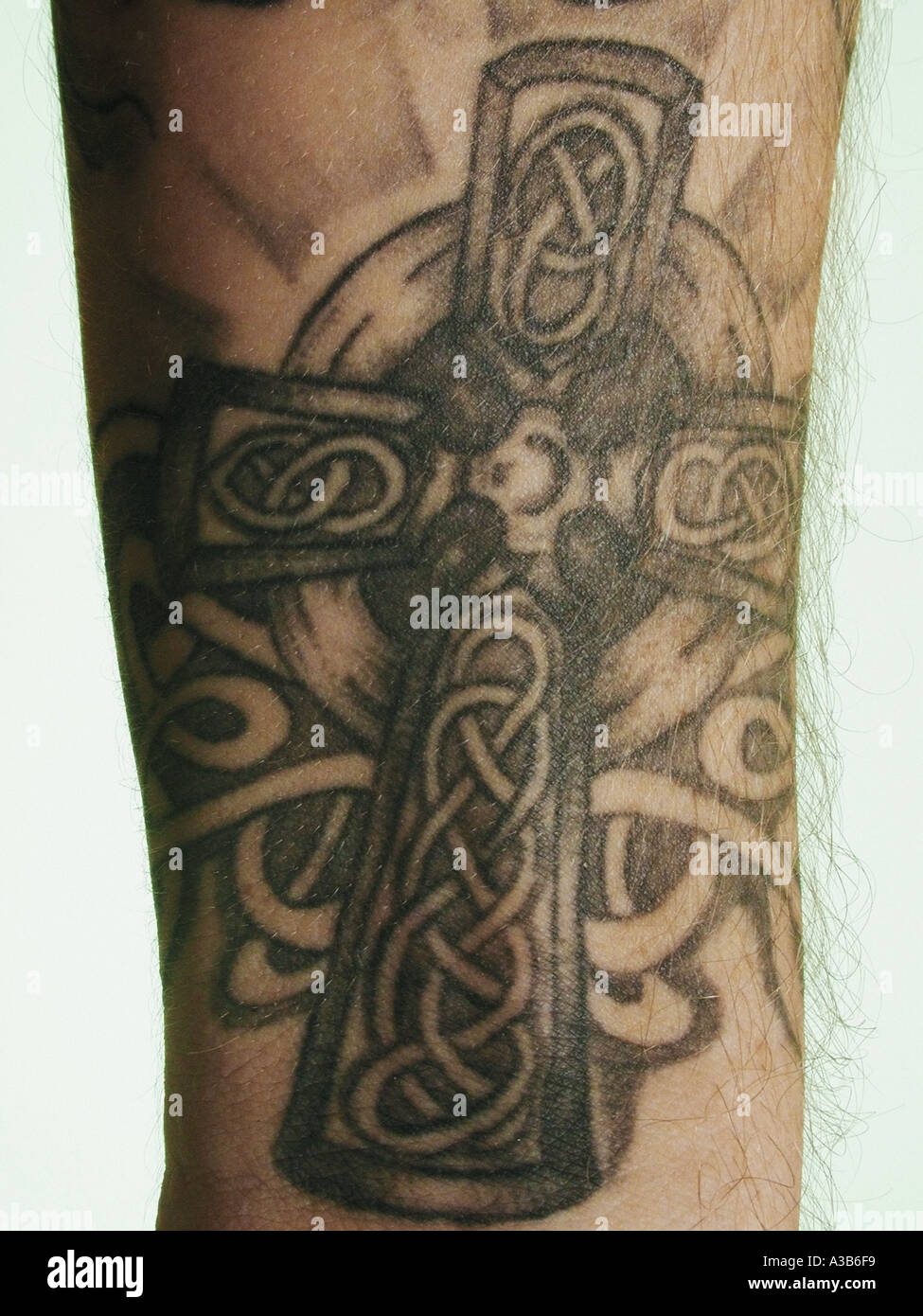 Crucifix tattoo on forearm of caucasian man close up Stock Photo