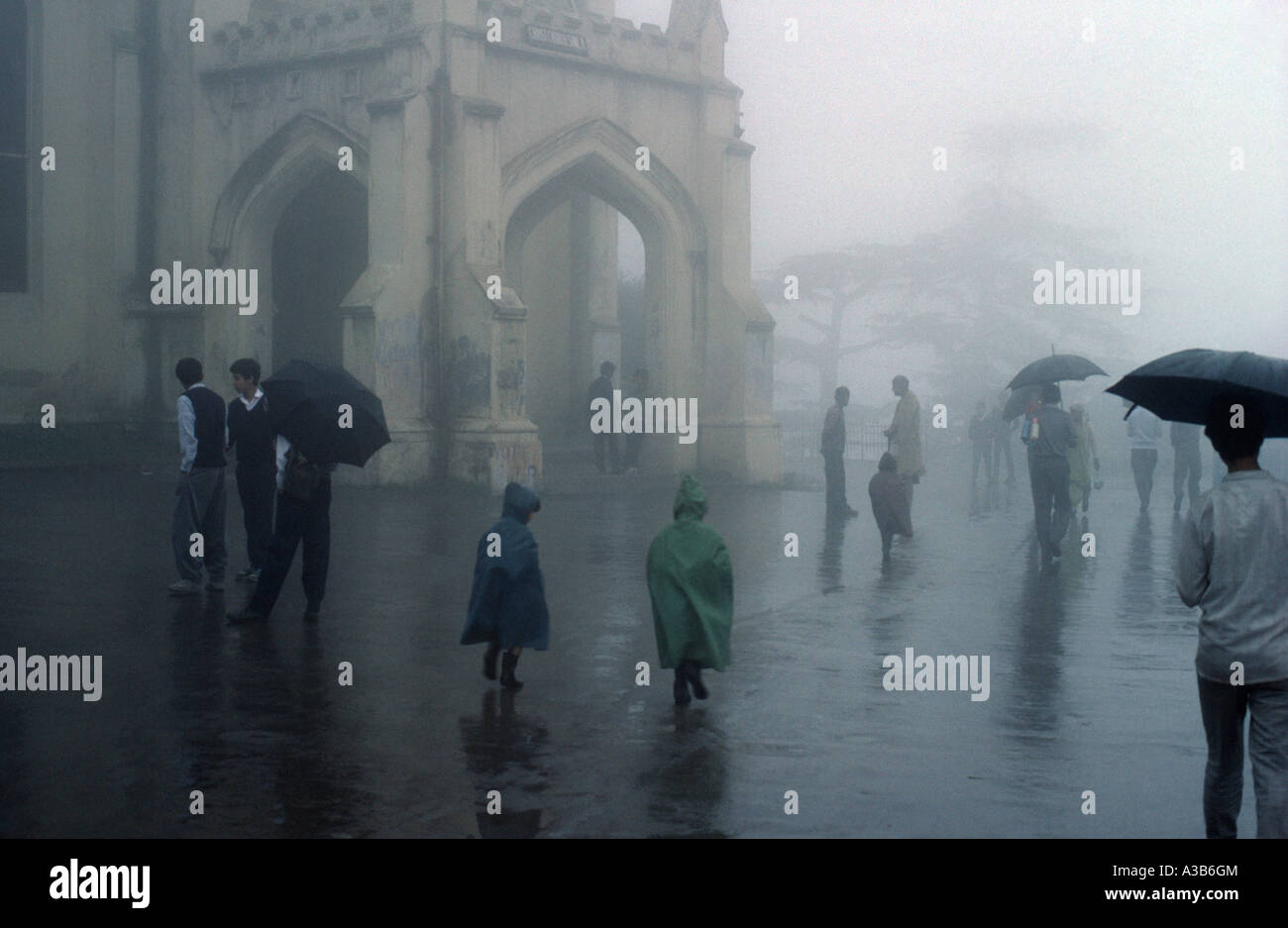 India South Asia Simla Monsoon rain falling with people walking with  umbrellas and children in mackintosh raincoats Stock Photo - Alamy