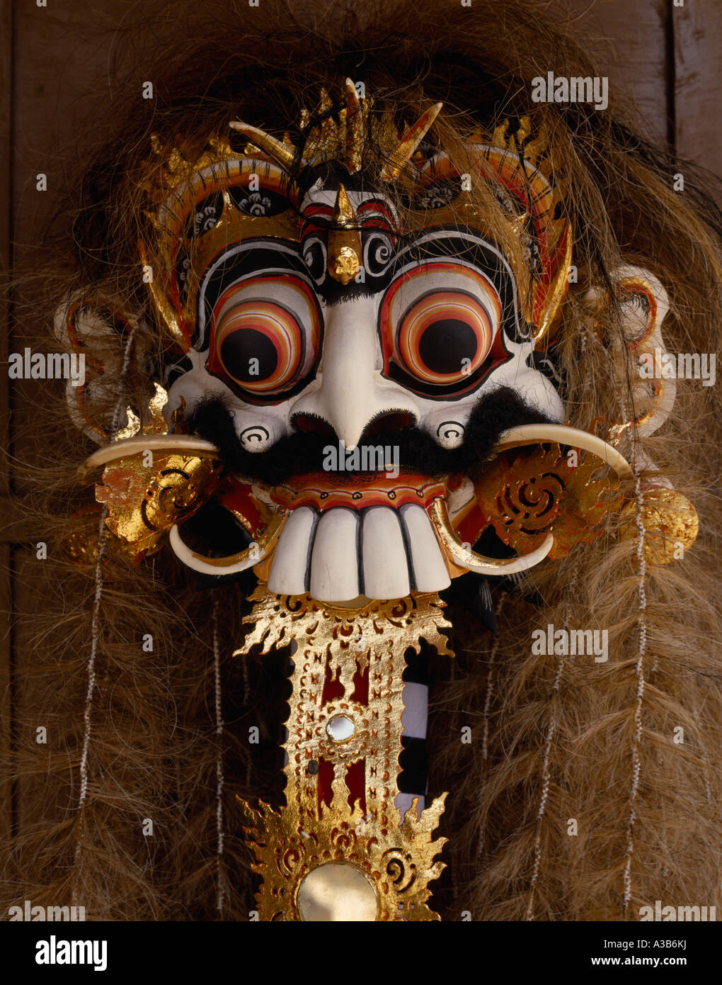 INDONESIA Southeast Asia Bali Traditional decorated ornate carved wooden dance mask with protruding eyes teeth and hair. Stock Photo