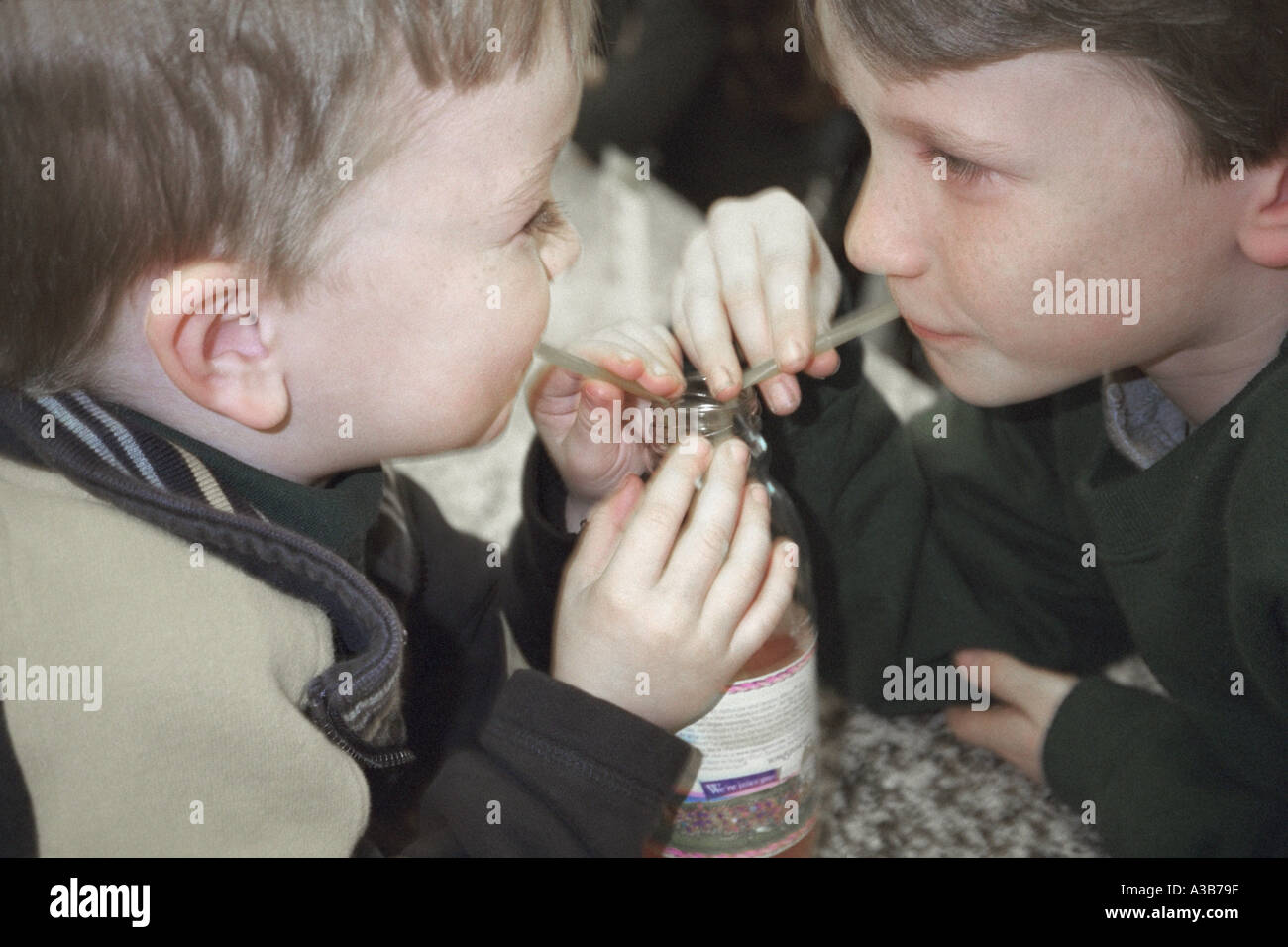 Two boys brothers sharing a drink Stock Photo Alamy