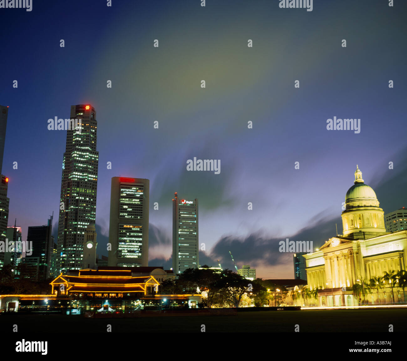 SINGAPORE Southeast Asia Raffles Place skyscrapers at night seen from the Padang with domed City Hall illuminated on the right Stock Photo