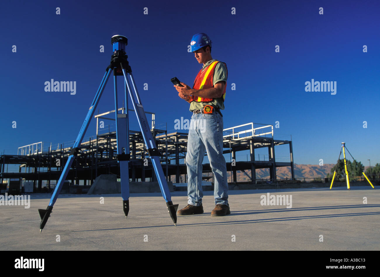 surveyor using GPS surveying unit at construction site in San Jose