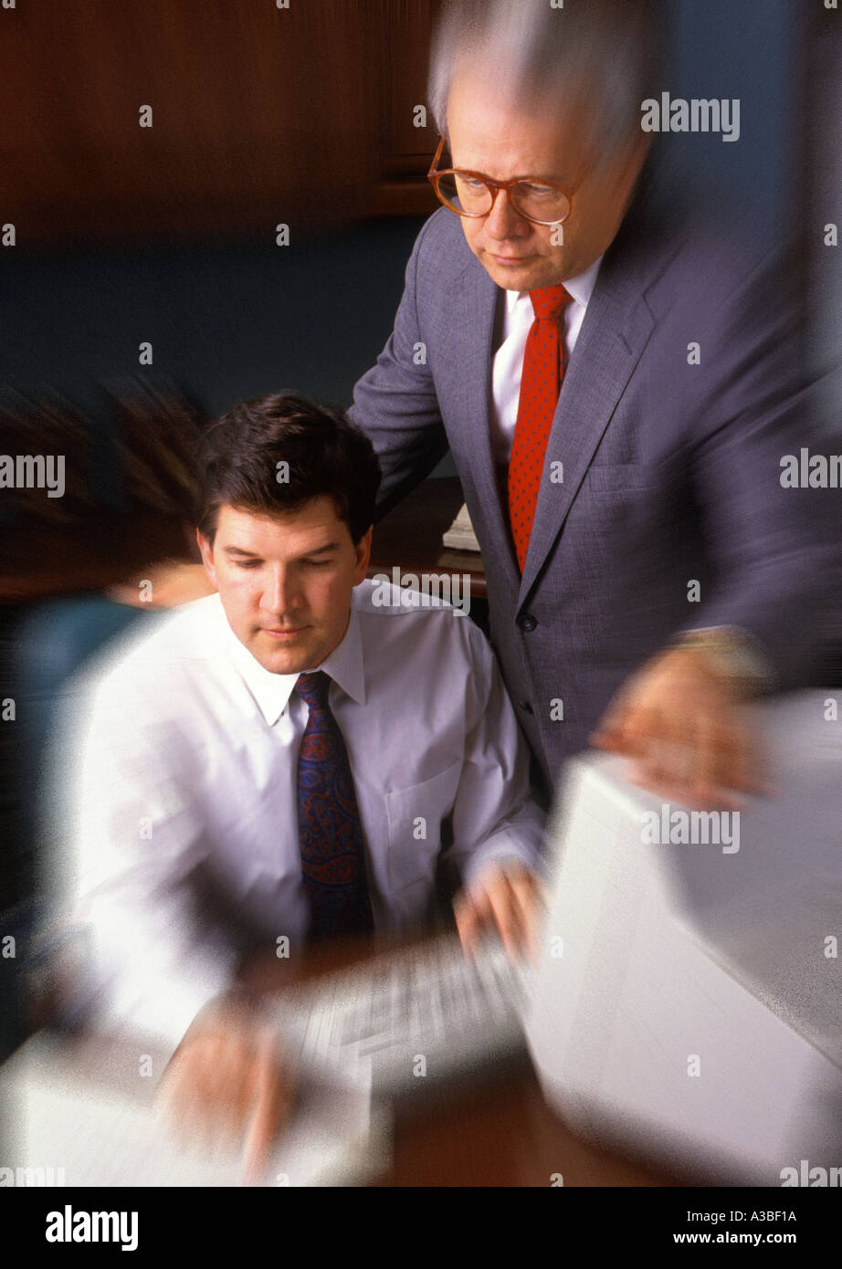 Two businessmen working on computer together blur Stock Photo
