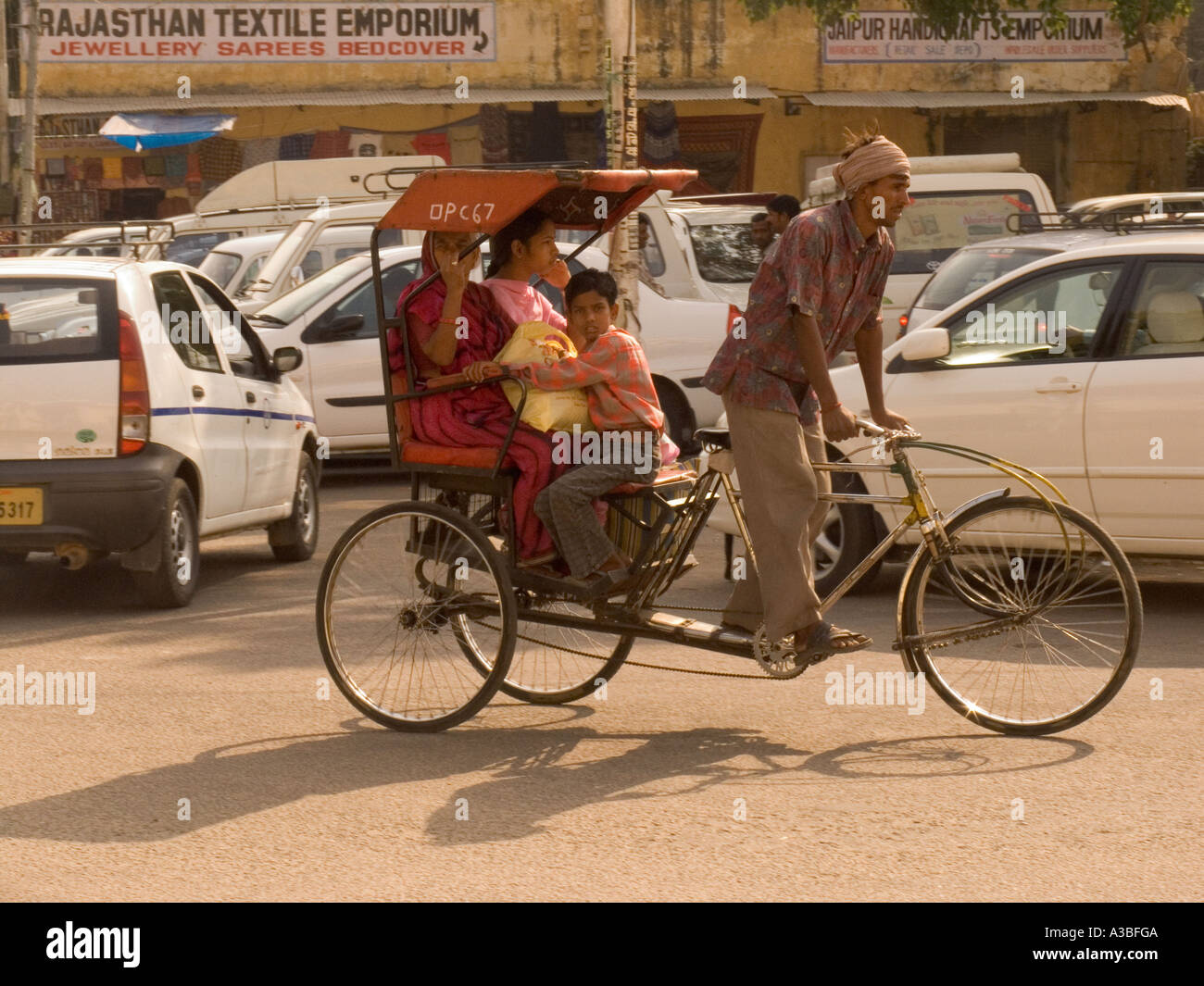 JAIPUR RAJASTHAN INDIA November Two ladies and a young boy riding in a bicycle rickshaw Stock Photo