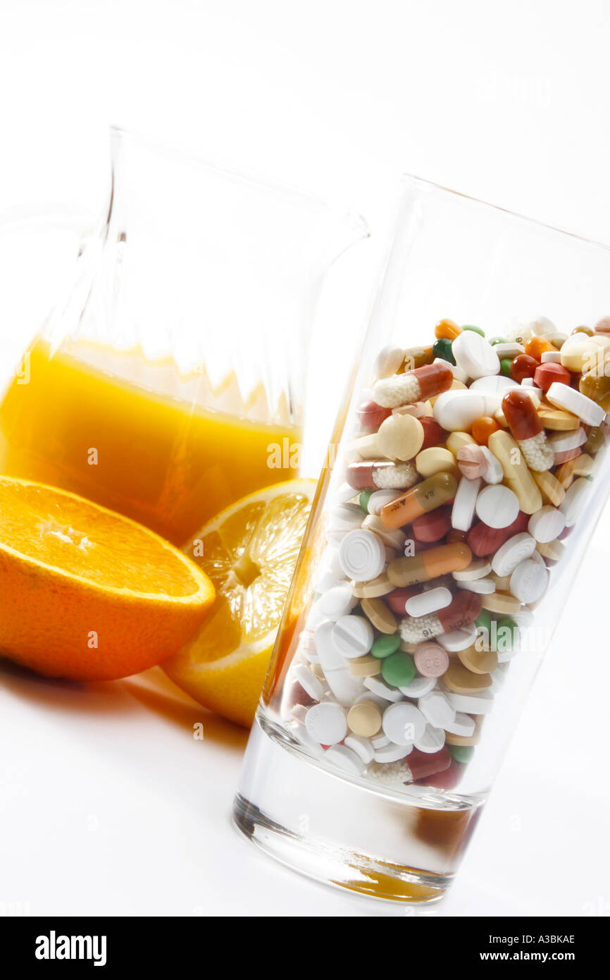 Orange juice and pills in glass, close-up Stock Photo