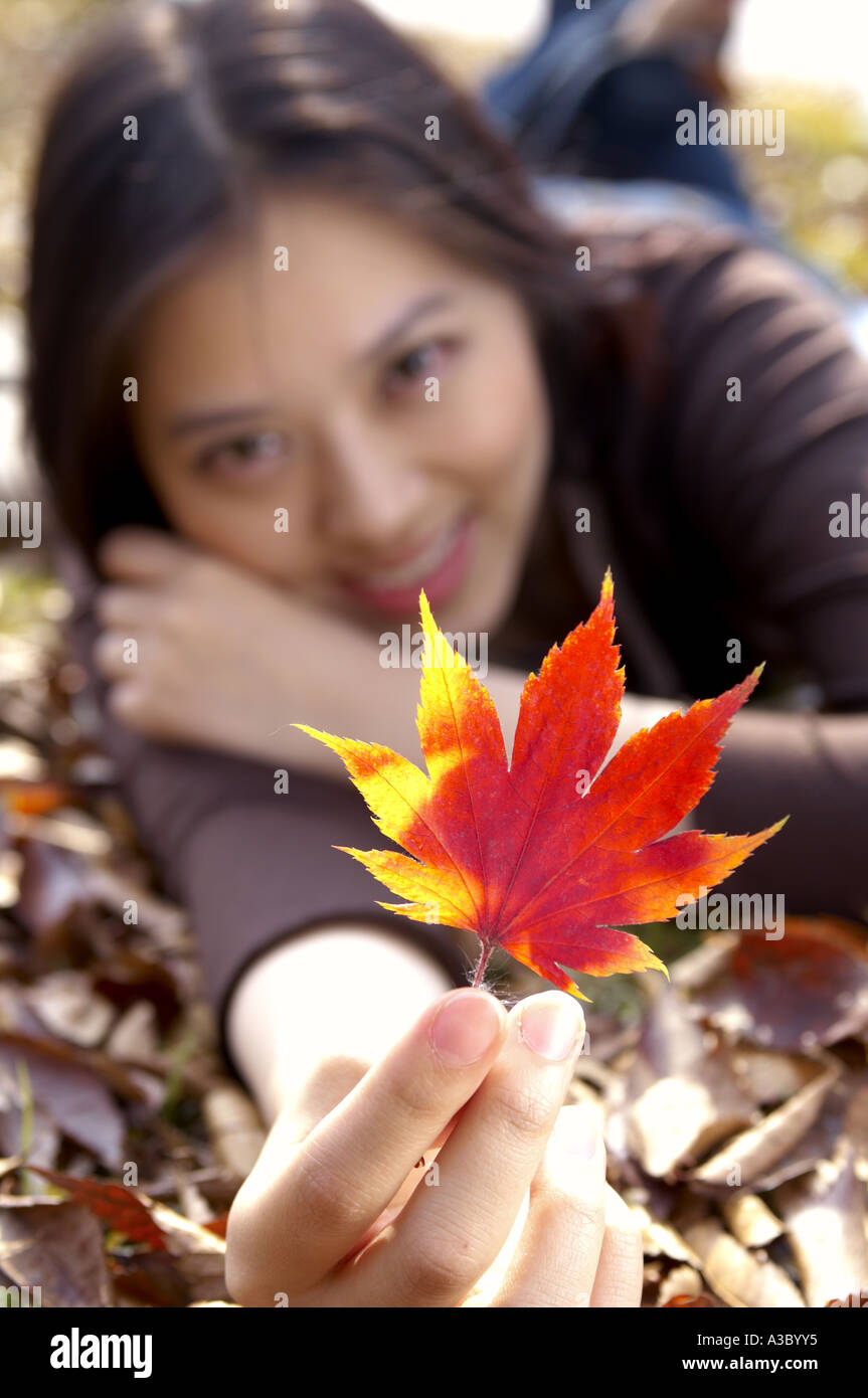 a girl is showing a maple leaf Stock Photo - Alamy