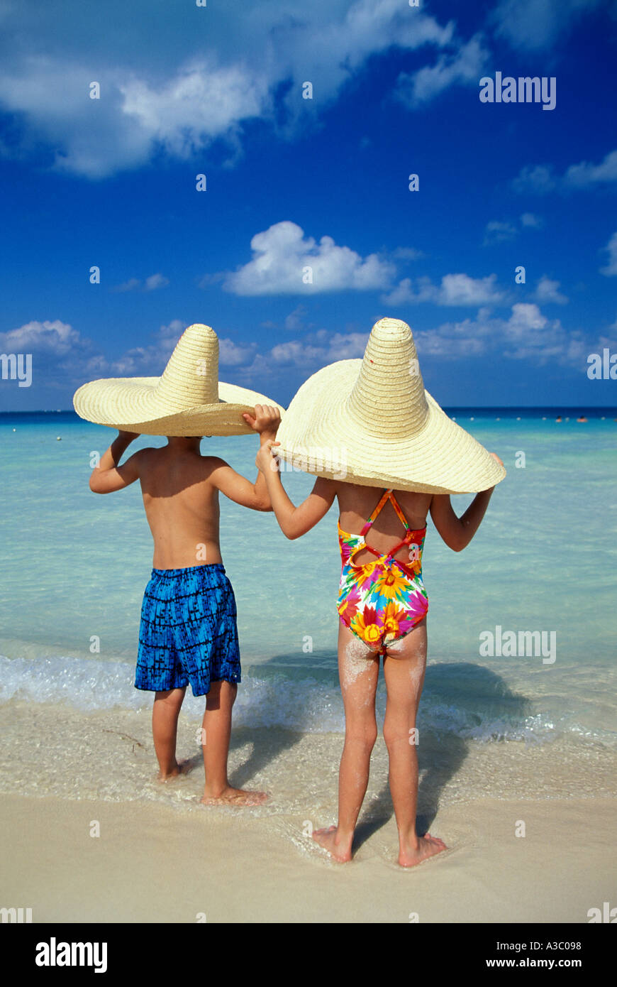 Children in Mexican hats on beach 7 yrs old Stock Photo