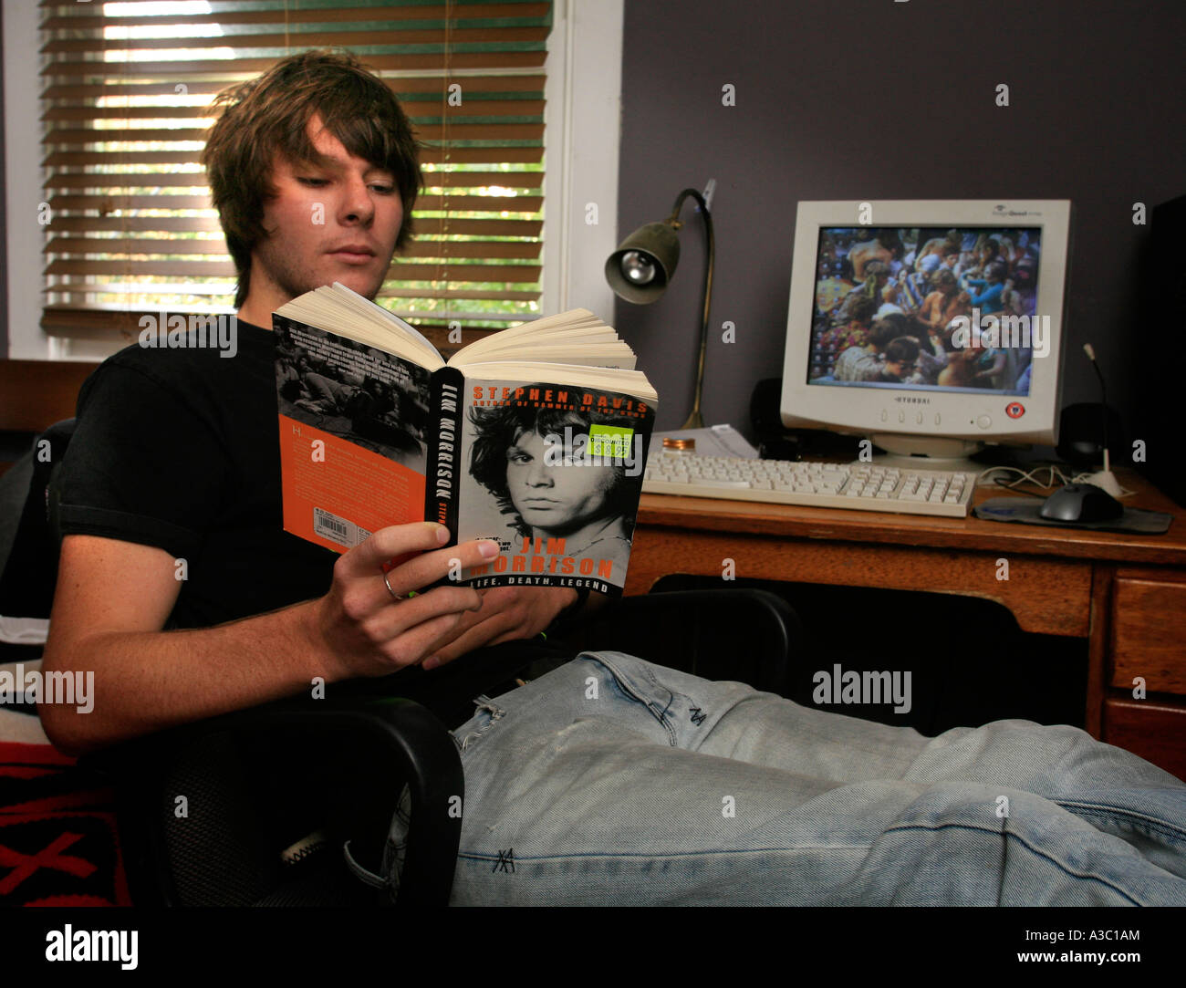 A Teen Aged Boy Reads A Biography About Doors Rock Lead Jim