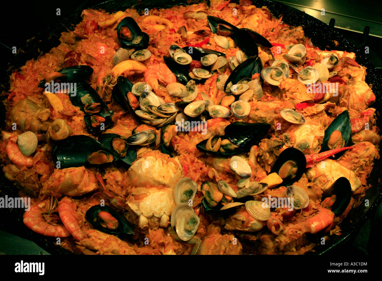 A close up photograph of a plain paella with crab claws squid chicken and pork Stock Photo