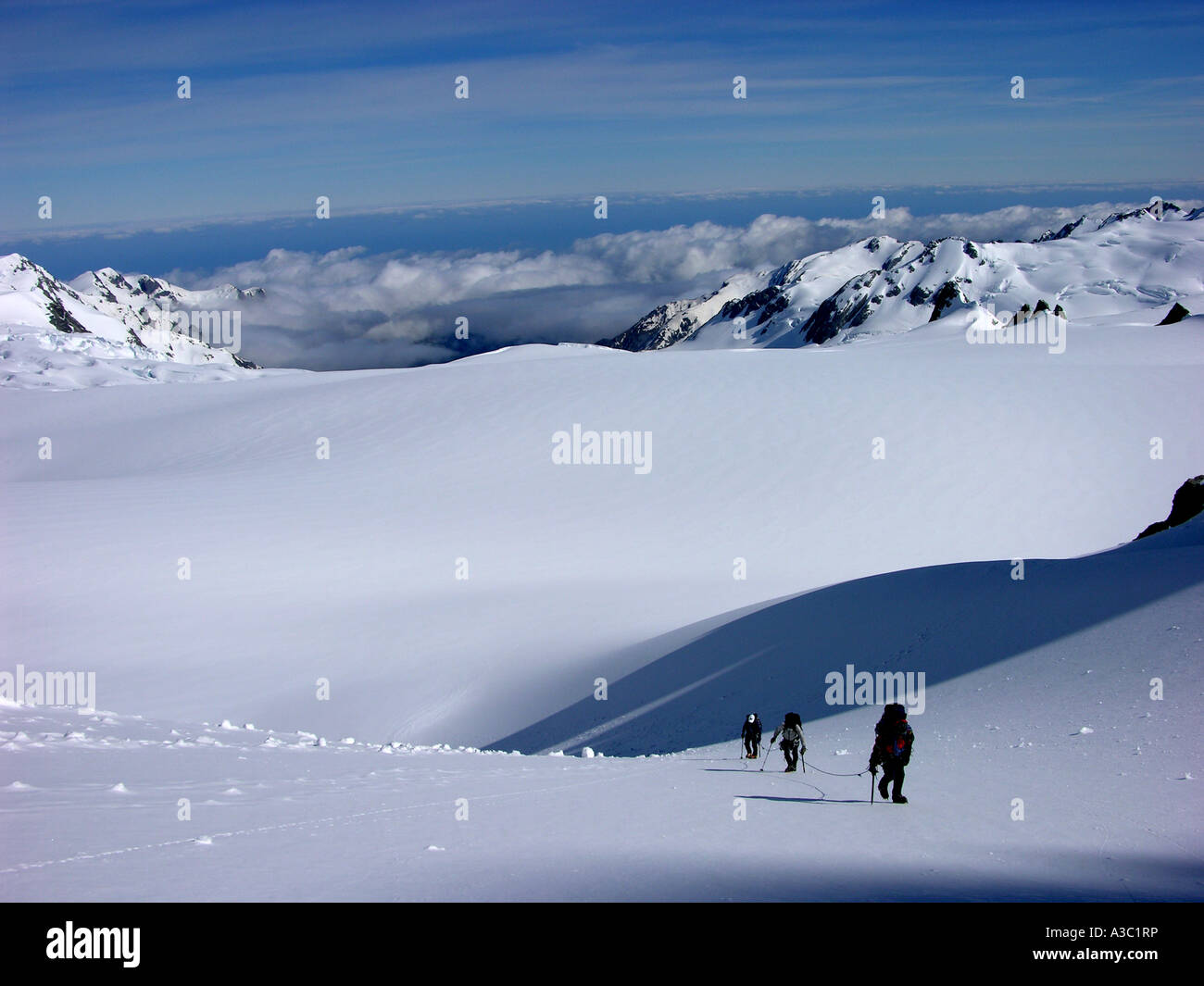 Roped up climbers pass through a Cym in New Zealands Southern Alps Stock Photo