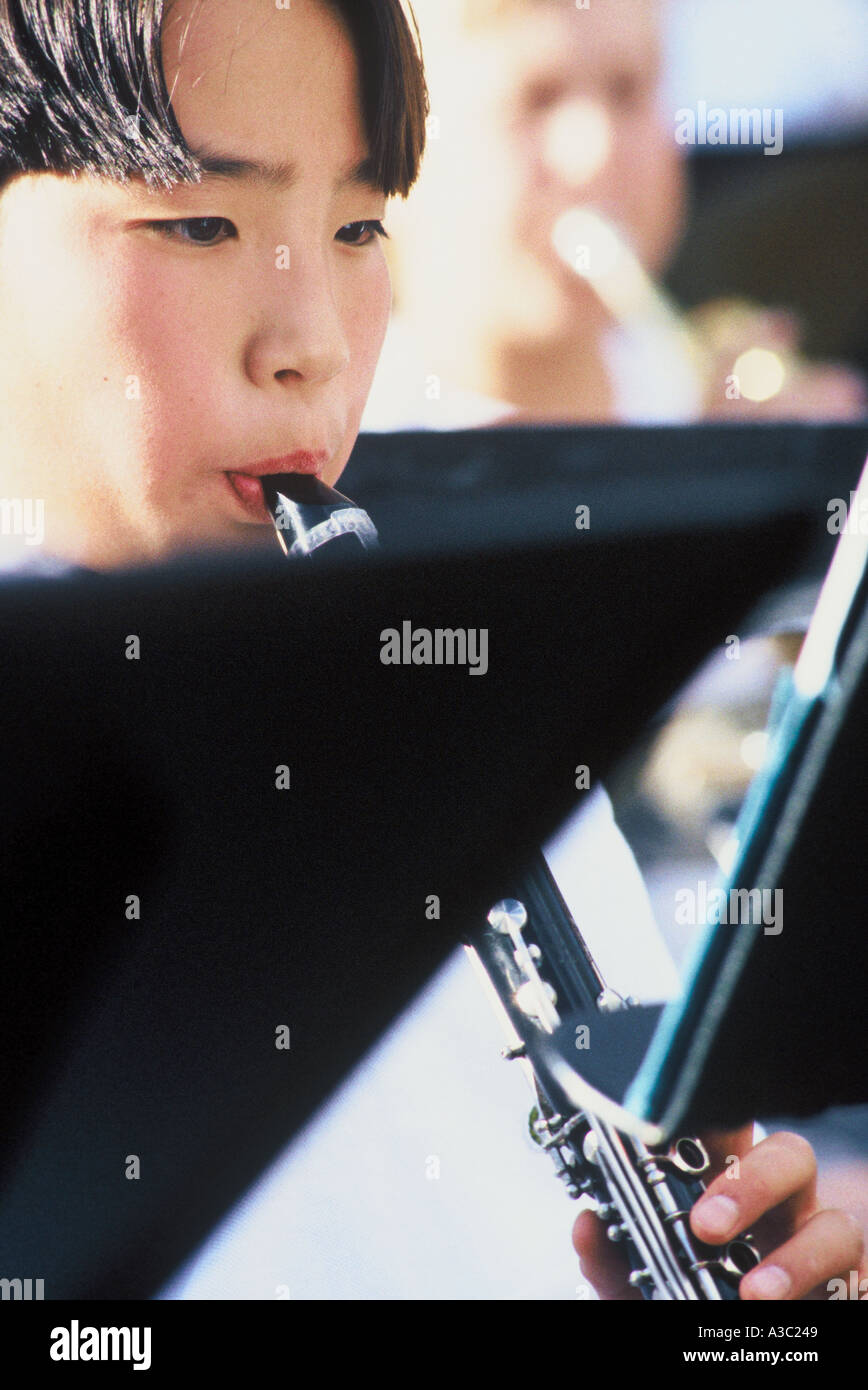 Close up of an Asian sixth grade boy playing the during a