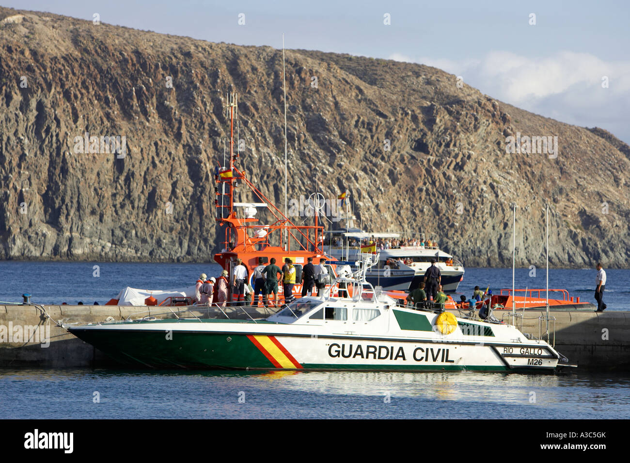 spanish guardia civil speedboat and orange rescue craft escorting african fishing boat full Stock Photo