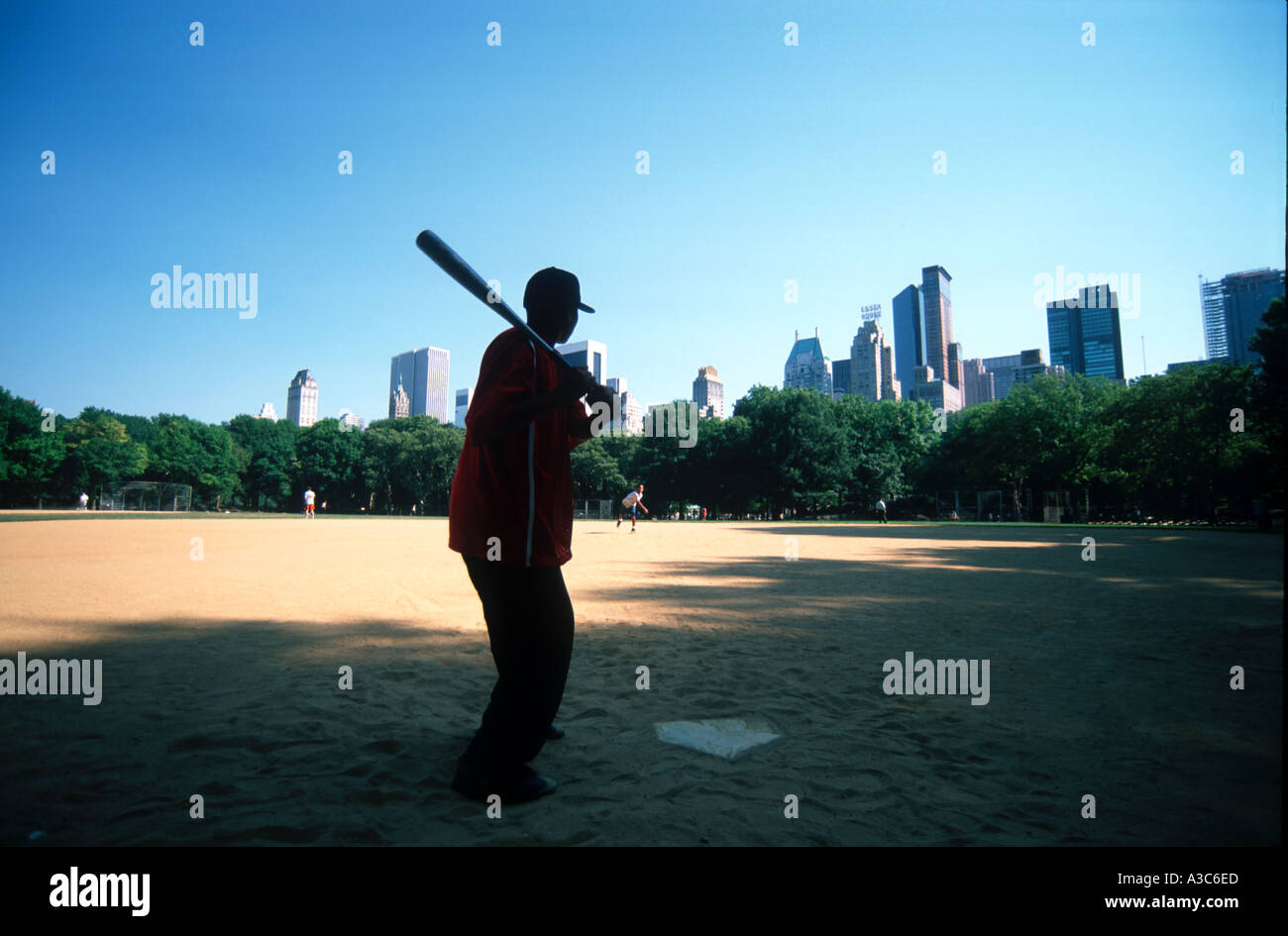 Two Boys playing Baseball on a field in Central Park Manhattan New York City USA Stock Photo