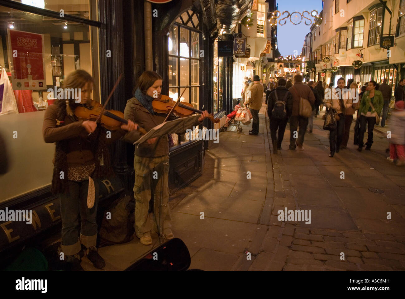 Buskers playing violins in a York street at Christmas Stock Photo
