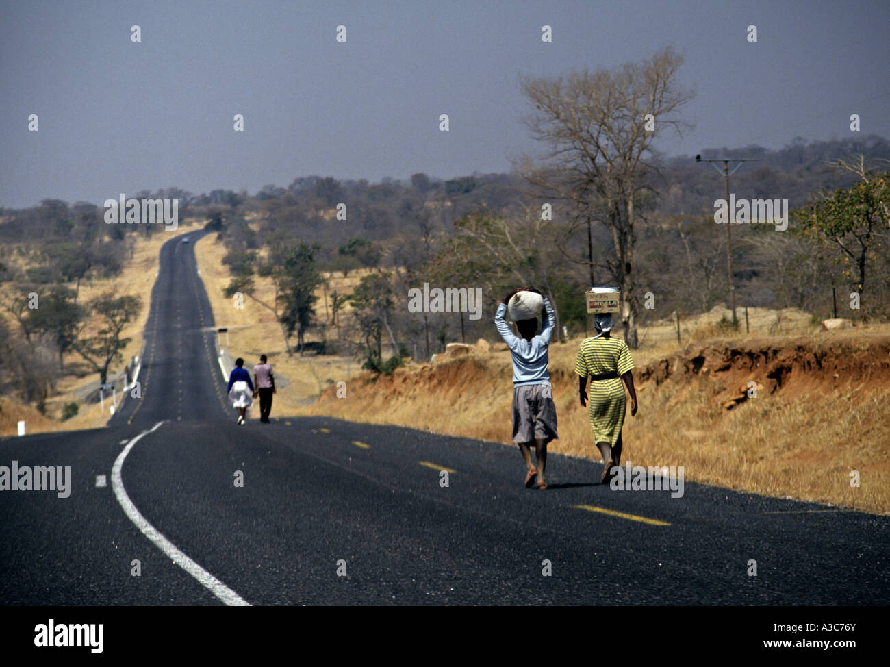 Women carrying goods on heads on road to Gweru Zimbabwe Stock Photo