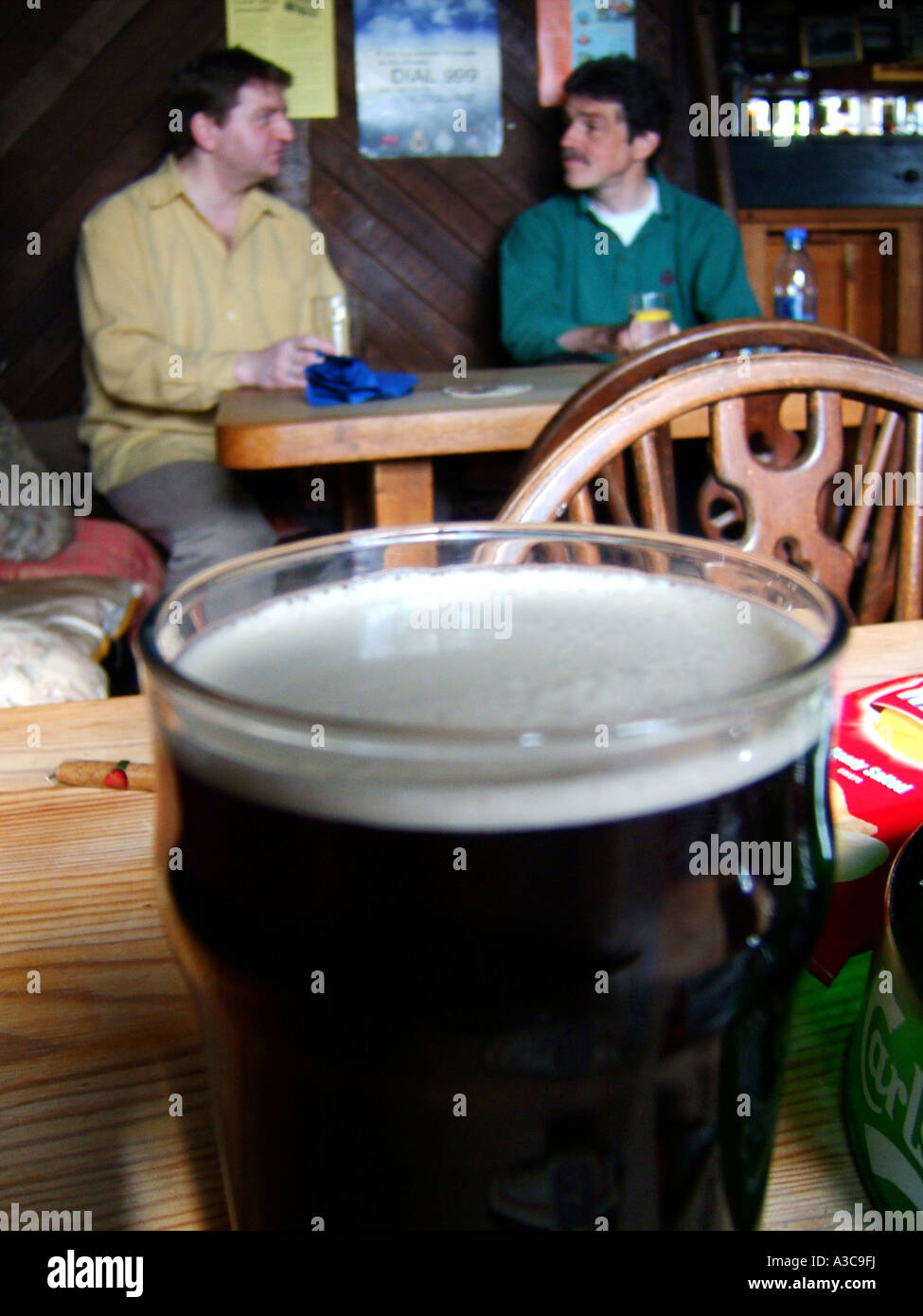 two men enjoying a pint in a pub Stock Photo
