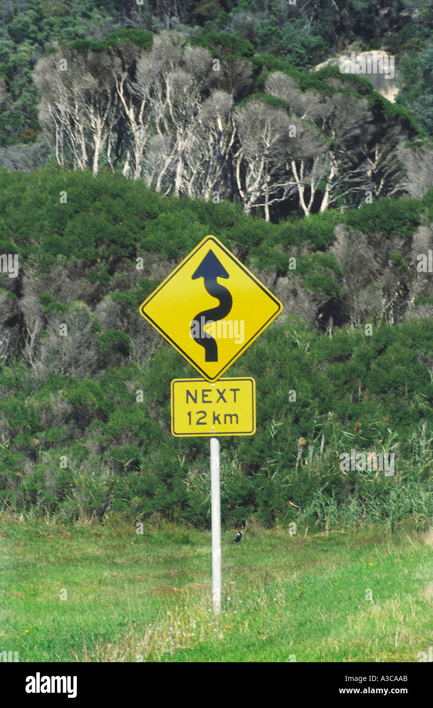 Man made sign in nature showing zig zag wavy curvy road ahead for next twelve kilometres, New South Wales, Australia Stock Photo