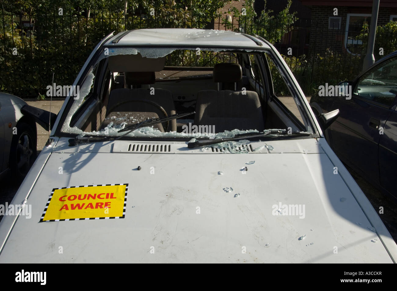 old white car wrecked and broken into with window smashed london england uk Stock Photo