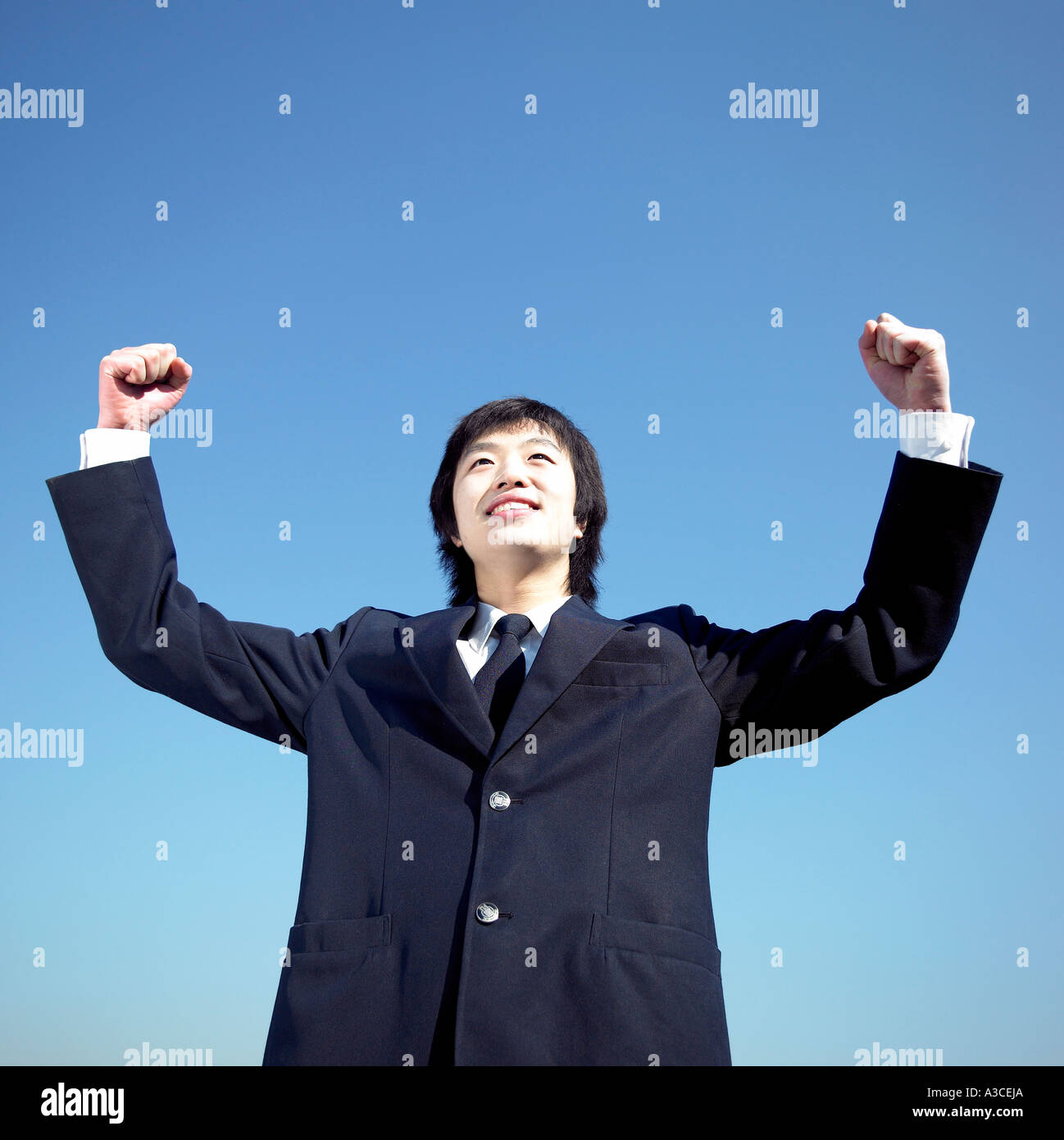 A teenage boy holding his arms in the air confidently Stock Photo - Alamy