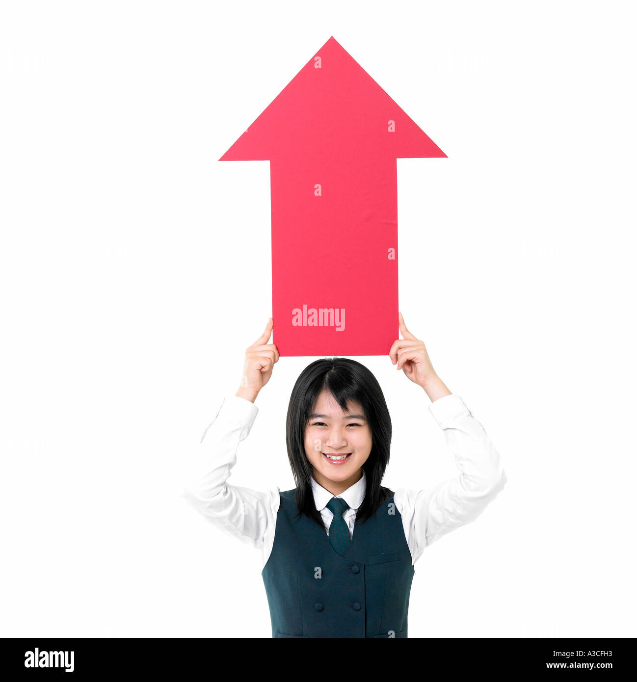 A female student in a school uniform is holding a red arrow over her ...