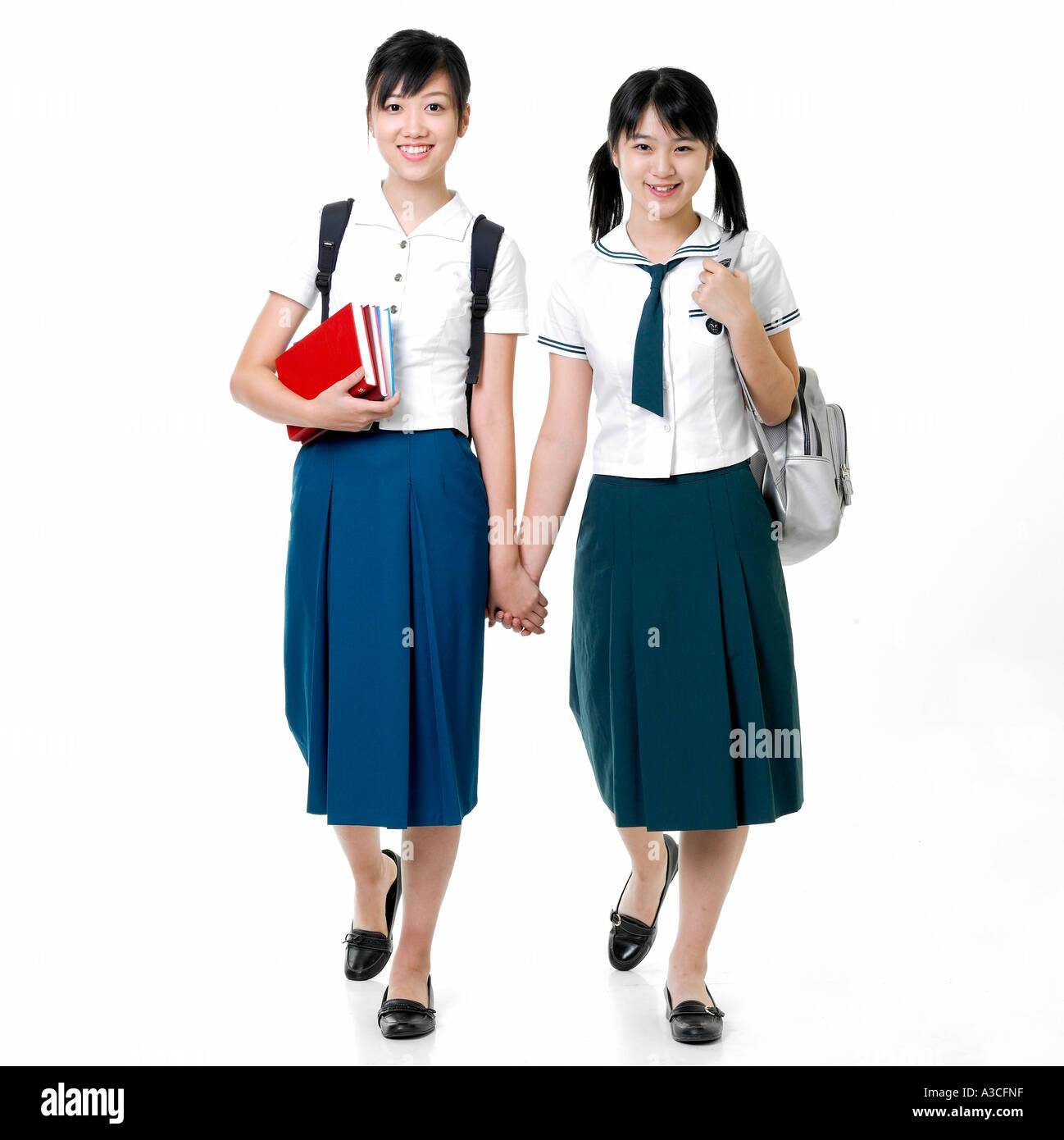Two female students with back packs are holding their hands Stock Photo