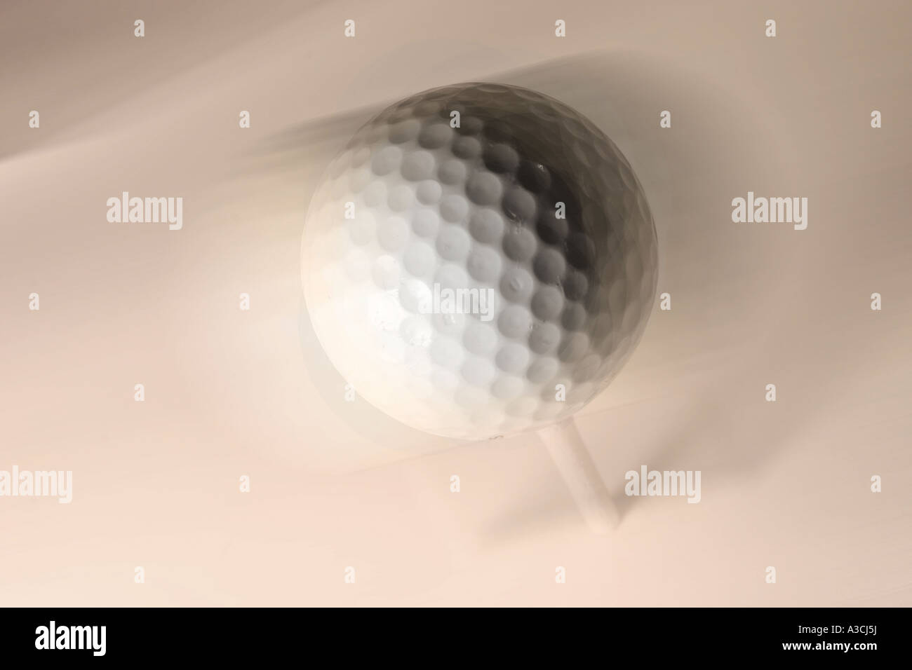White golf ball on tee peg with motion blur Stock Photo