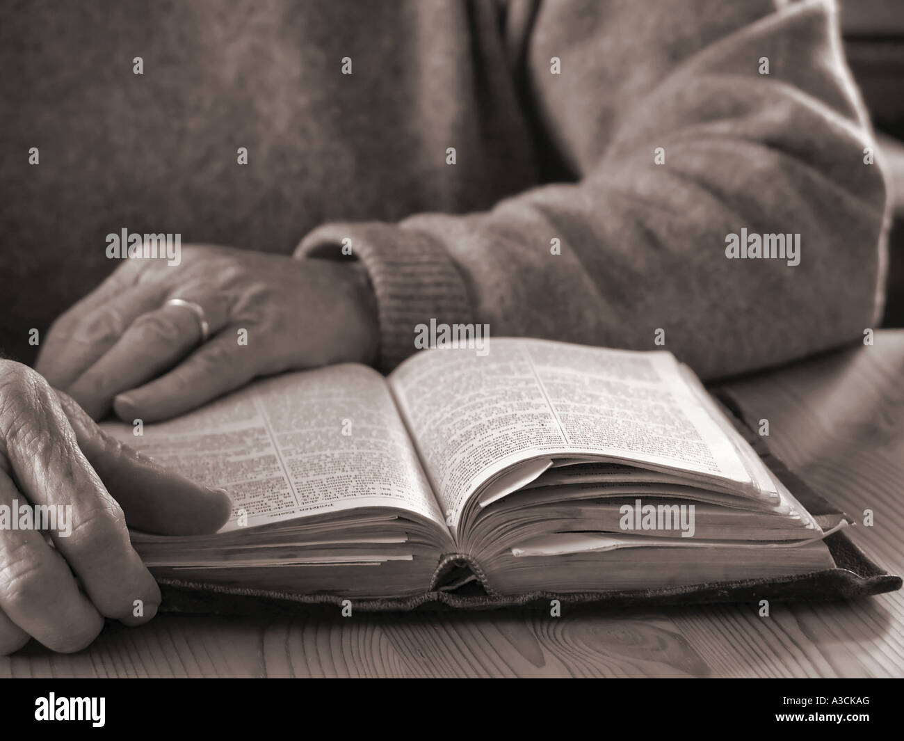 Elderly hands and old, worn Bible Stock Photo