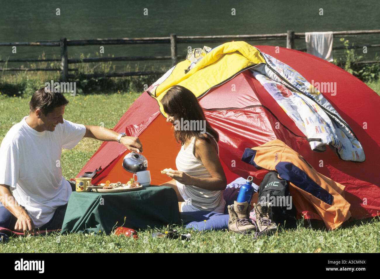 couple sitting in front of a camping tent having breakfast Stock Photo