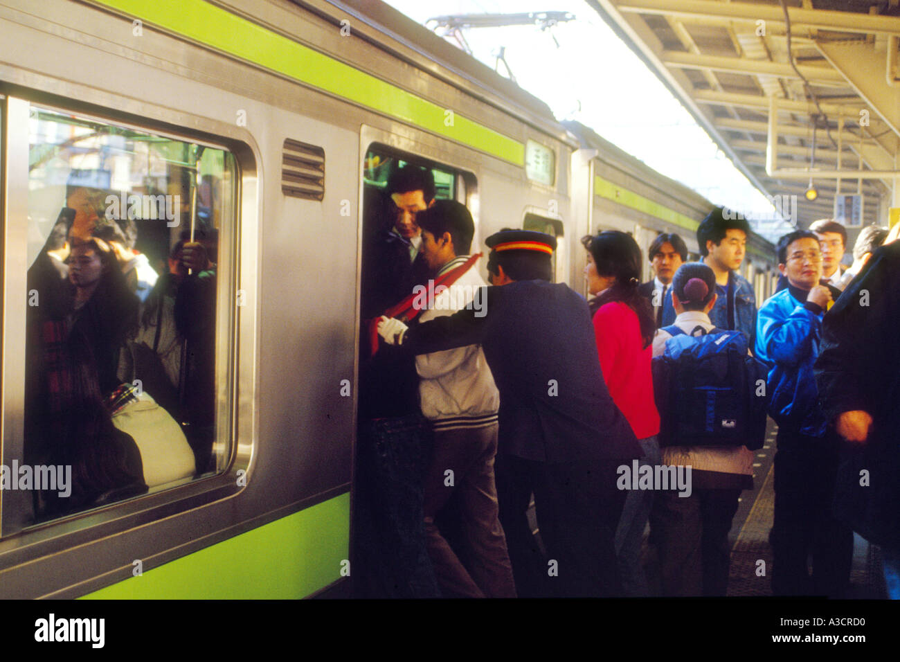 Asia Japan Tokyo Shinjuku station rush hour crowded crowds commuters. Train pushers push as many passengers as possible in rush Stock Photo