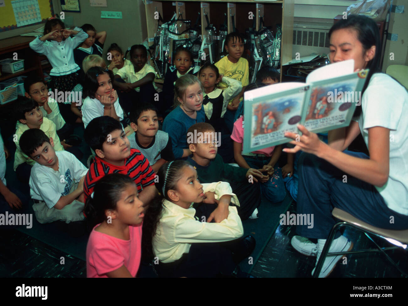 Teacher reads a book to 1st graders at a Brooklyn NY public school Stock Photo