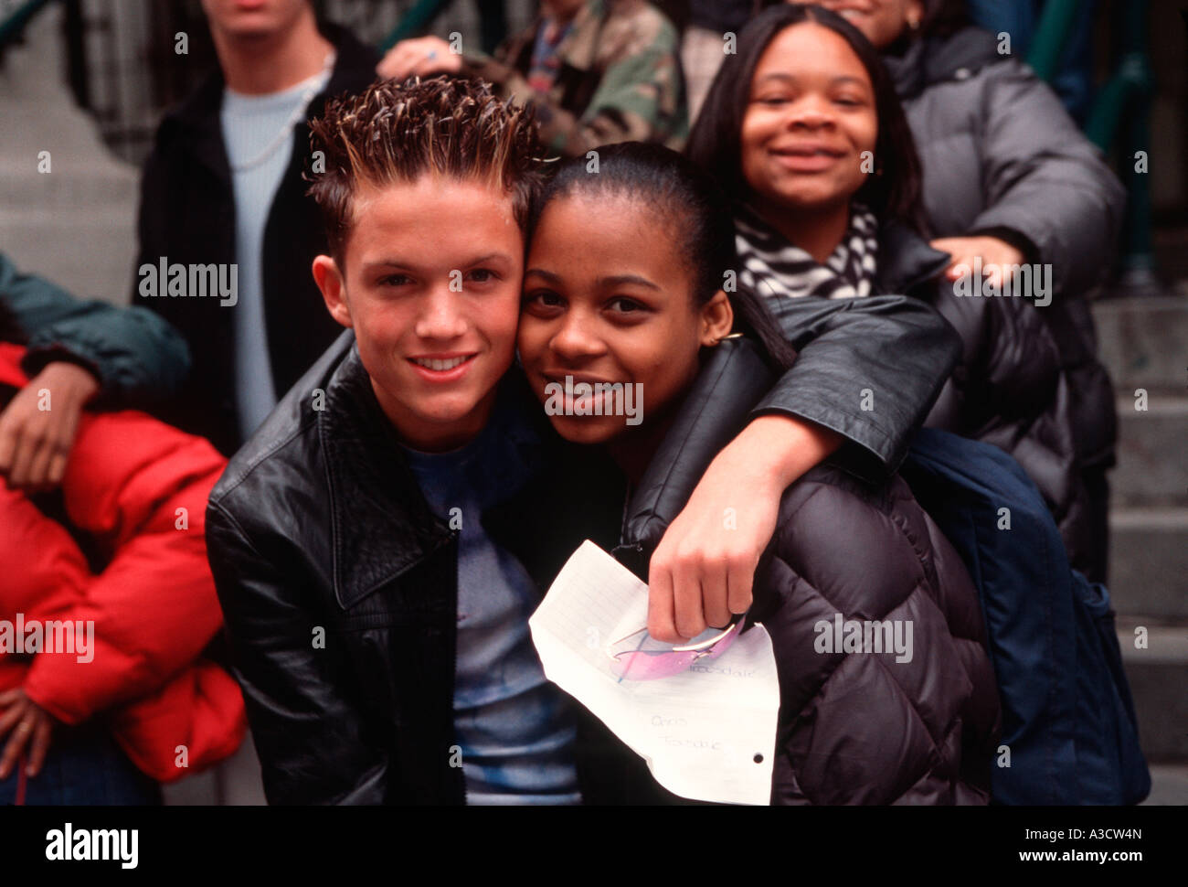 two high school students pose in front of their school in New York City Stock Photo