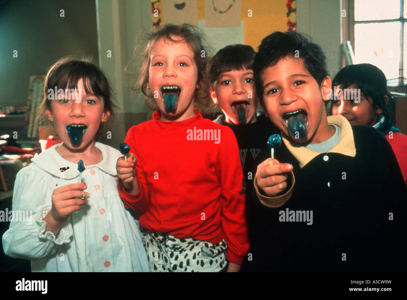 Kindergarten children showing how cool the color of their lollipops are in a Brooklyn New York public school Stock Photo