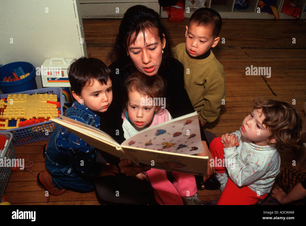 Nursery School Teacher Reads A Story To A Group Of Children At Free Stock Photo Alamy