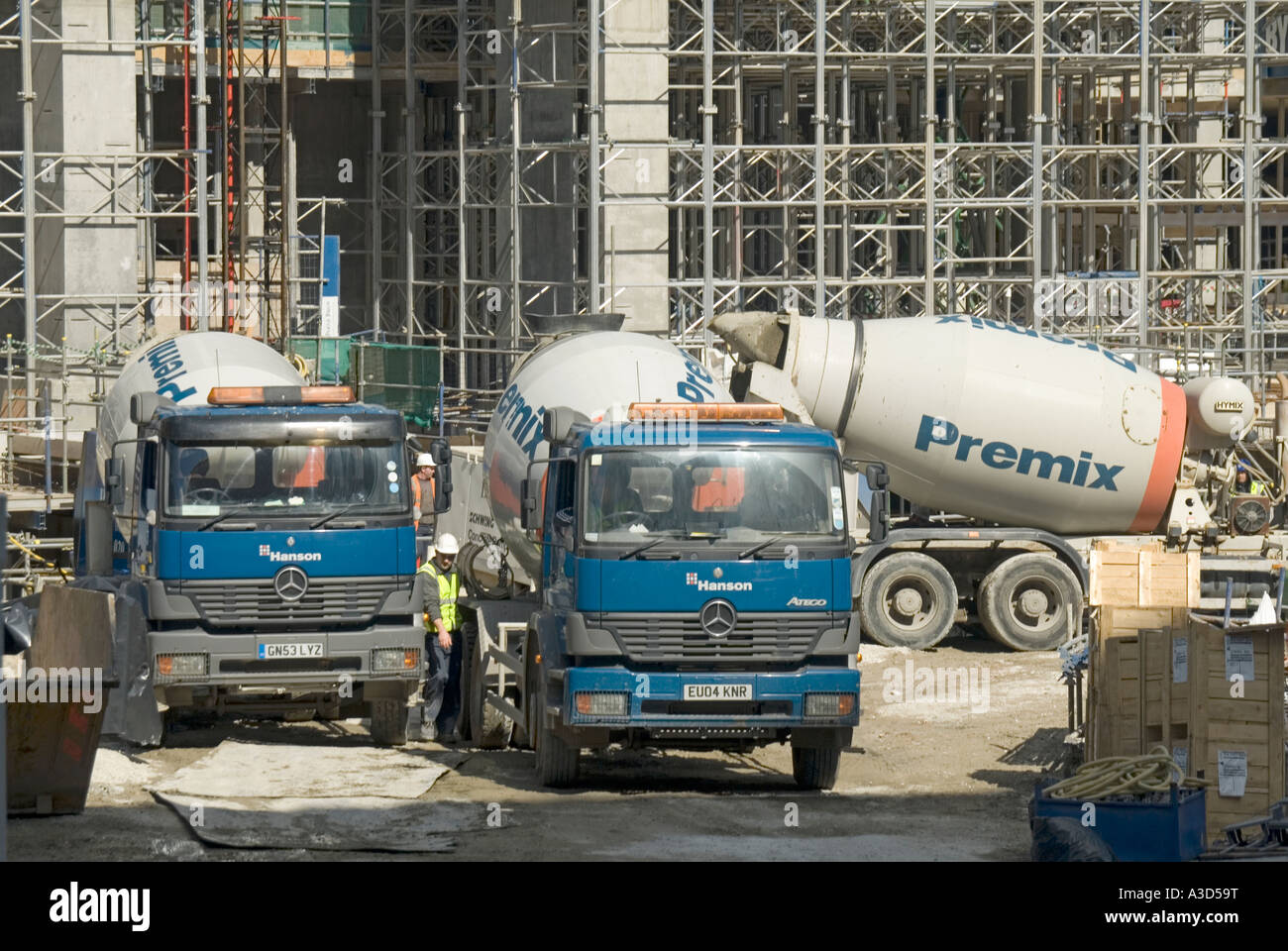 Hanson Mercedes readymix concrete delivery trucks parked awaiting unloading on construction site Stock Photo