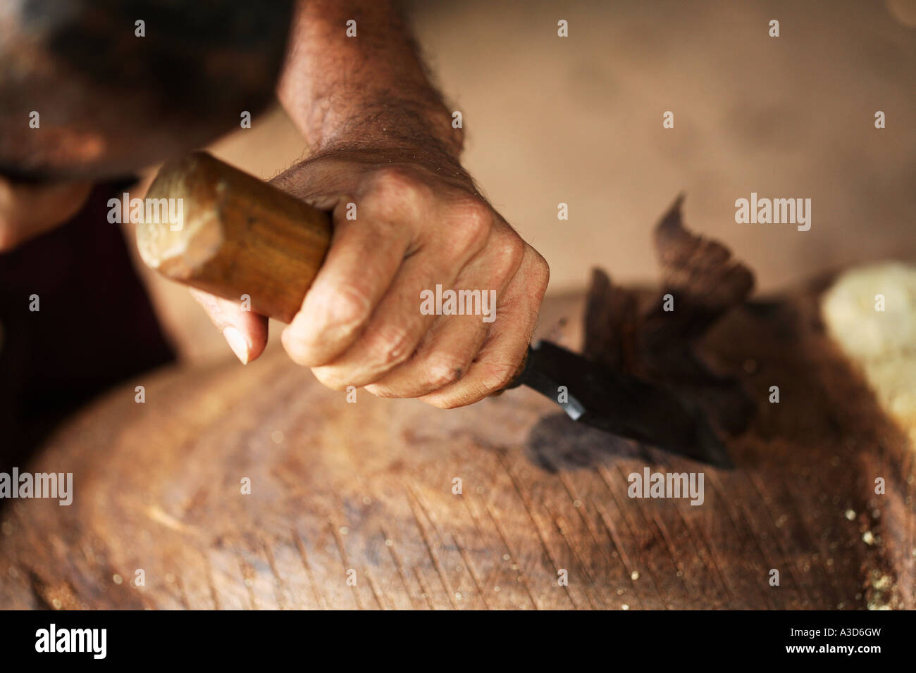 Elephant Chisel Environmental portrait of wood carver with hammer and chisel, making ...