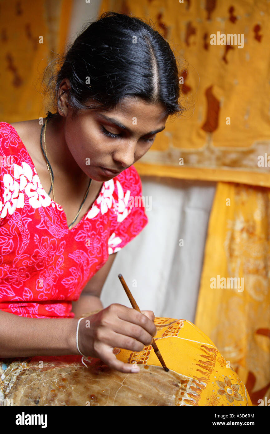 Local woman in batik factory, Kandy, Sri Lanka, decorating material with wax design in bright colour Stock Photo