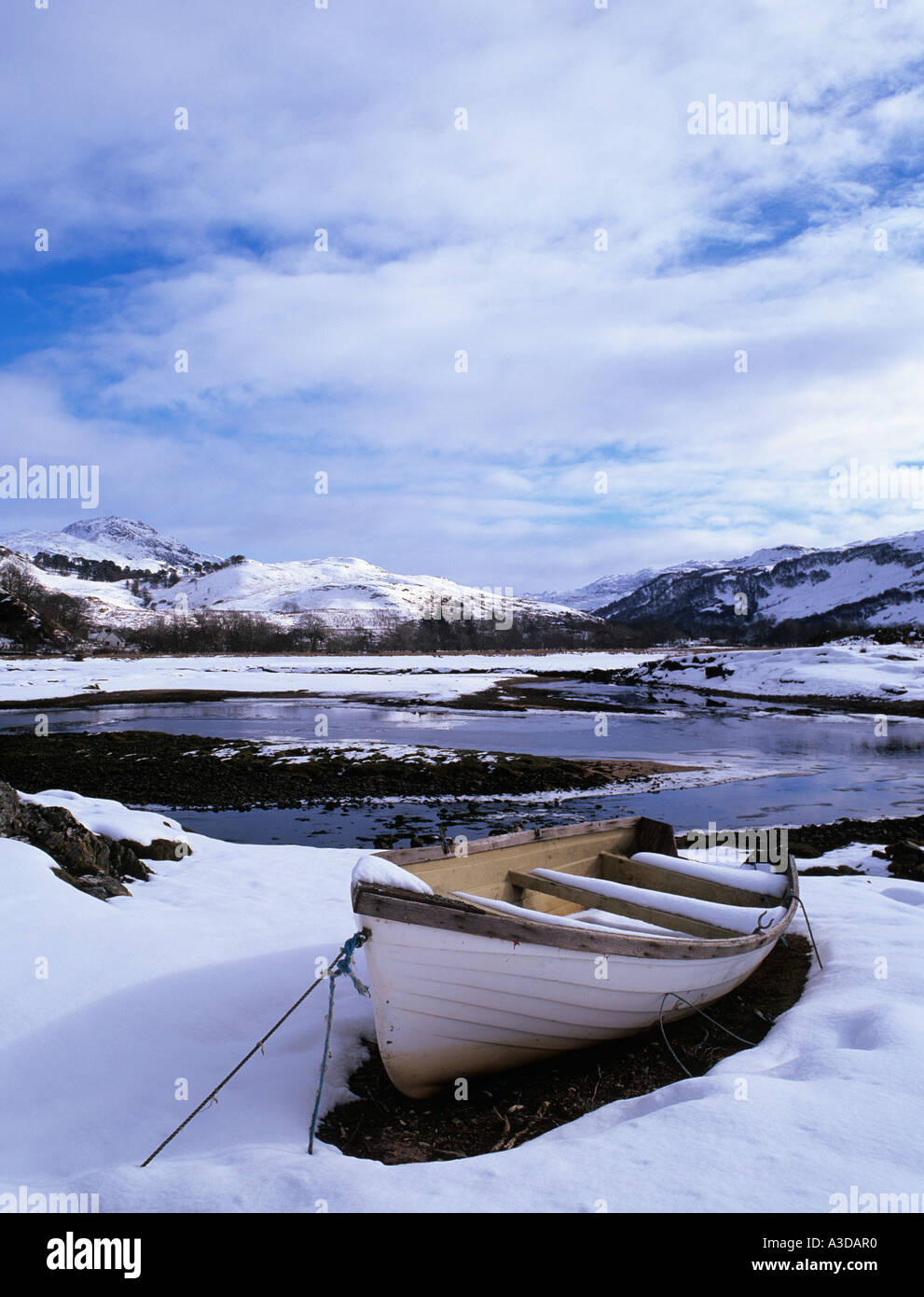 Wooden boat by Glenmore River estuary in Galltair with snow on ground in winter Glenelg Highland Scotland UK Britain Stock Photo