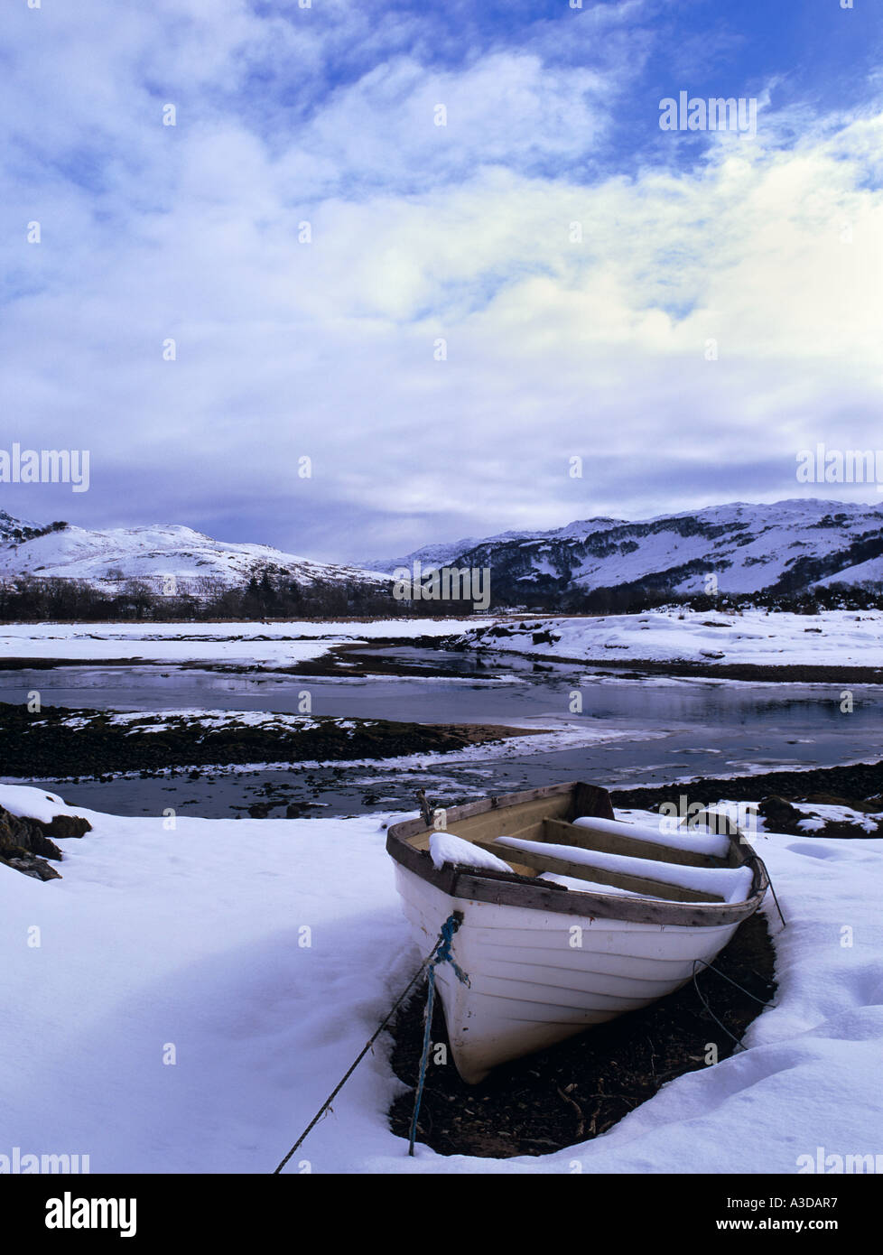 Wooden boat by the Glenmore River estuary in Galltair with snow on ground in winter Glenelg Highland Scotland UK Britain Stock Photo